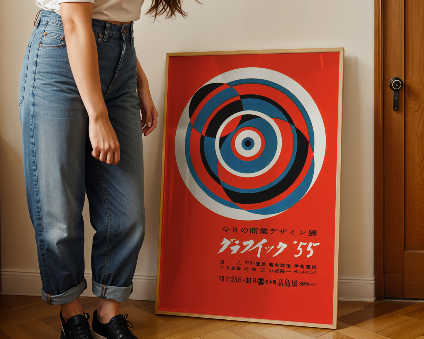 Person standing next to a red poster with concentric circles and text on a wall.