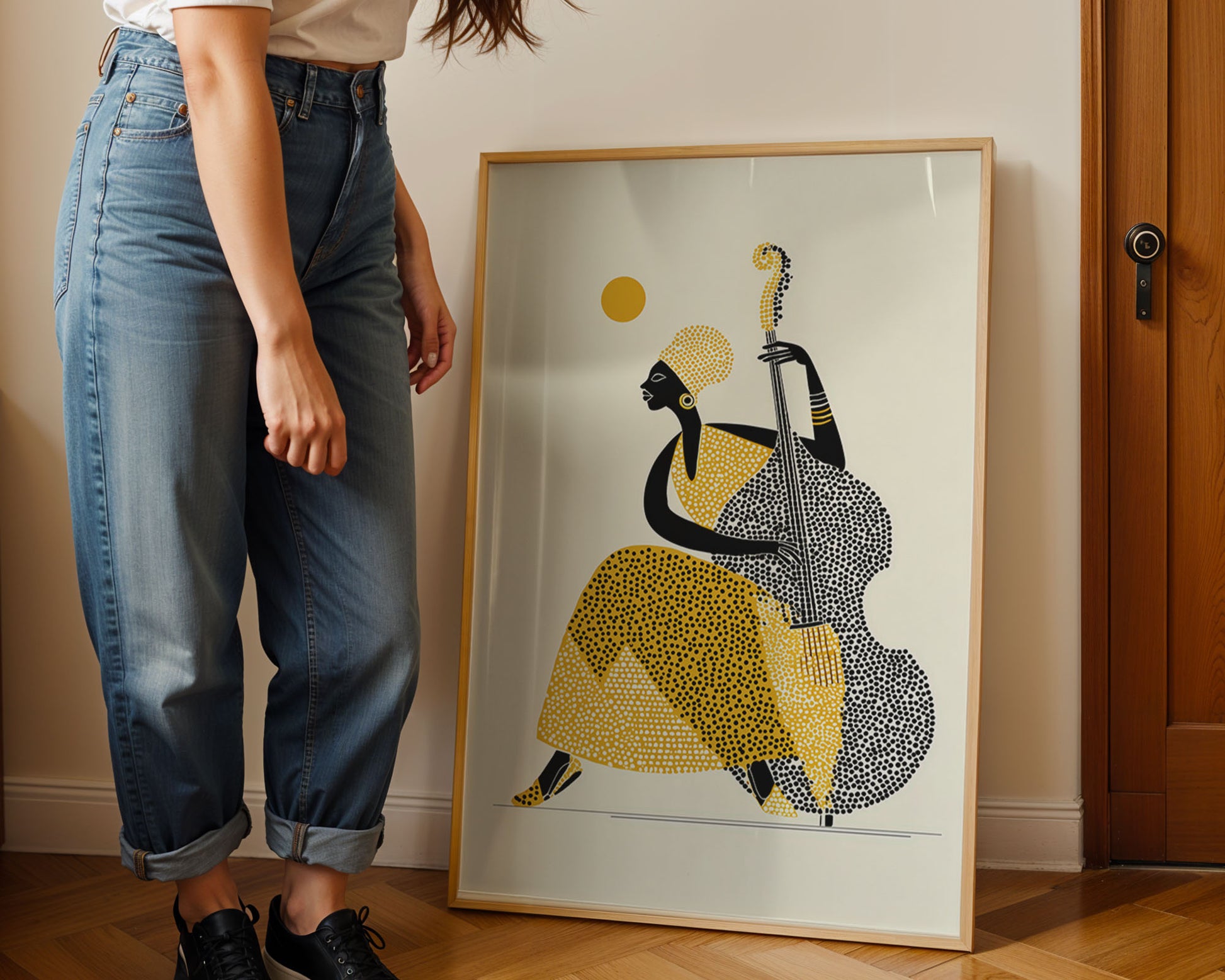 Person standing next to a framed artwork of a stylized figure playing a double bass.