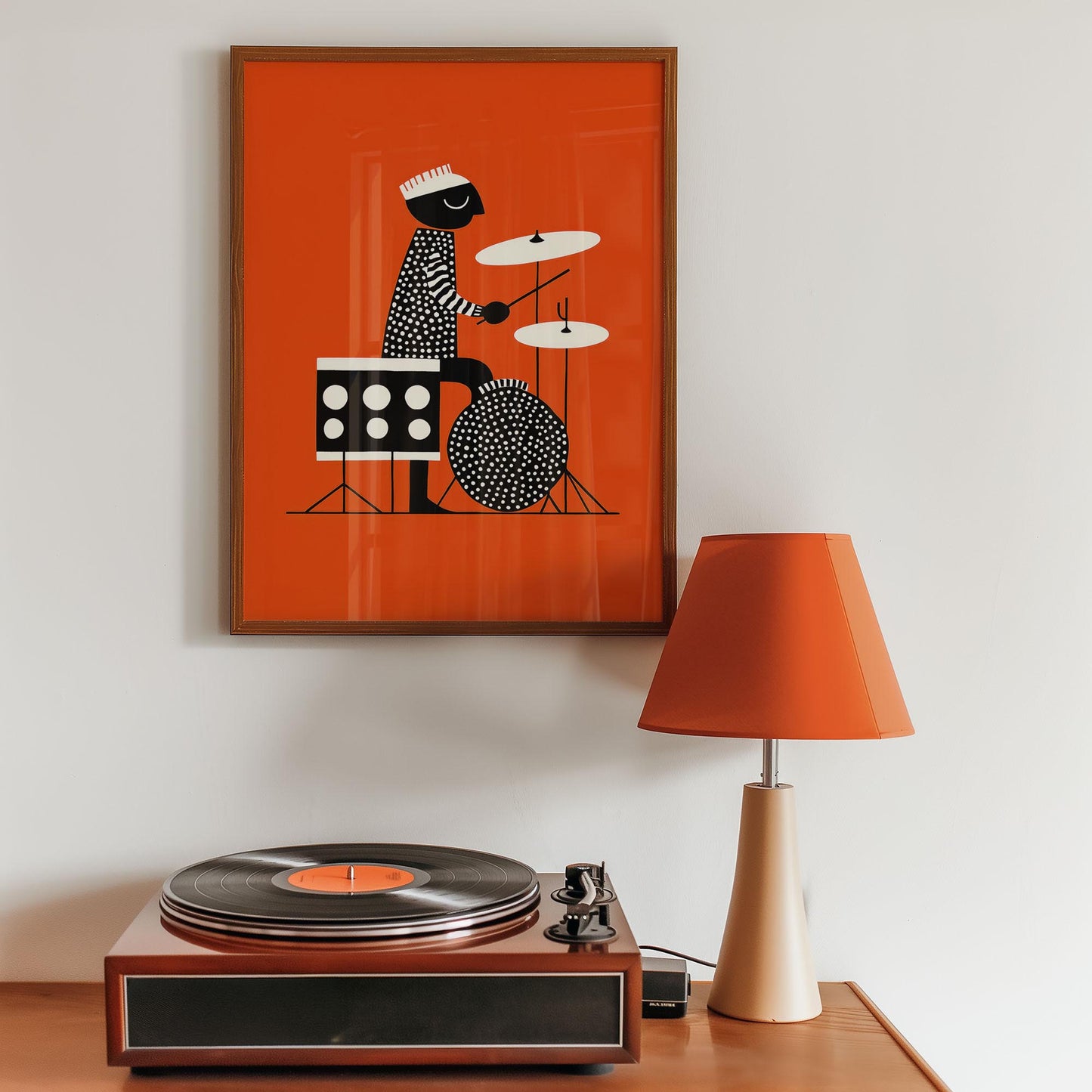 Framed artwork of a drummer on an orange background above a record player with a lamp.