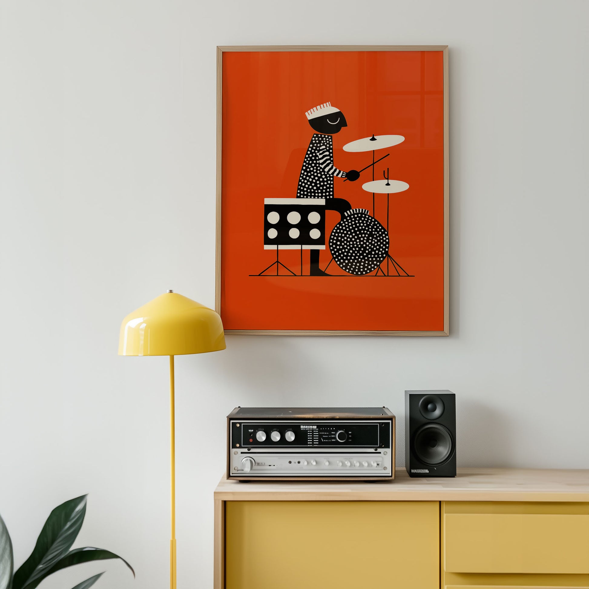 Framed artwork of a drummer on an orange background above a yellow cabinet with stereo equipment.