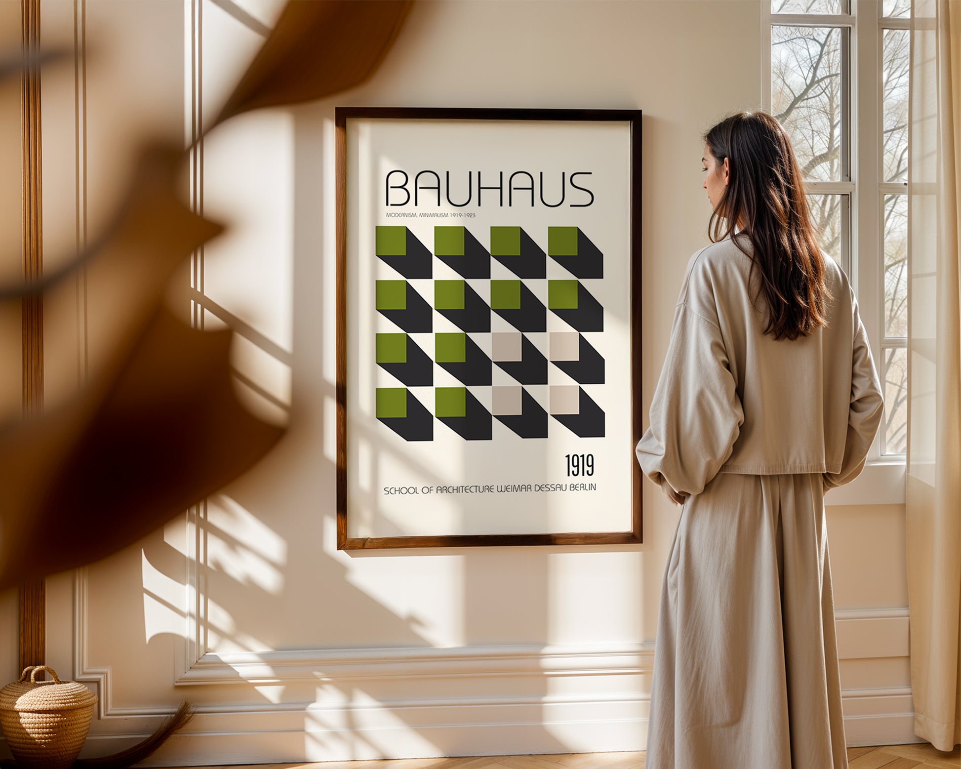Woman standing in a room looking at a 'Bauhaus' poster on the wall.
