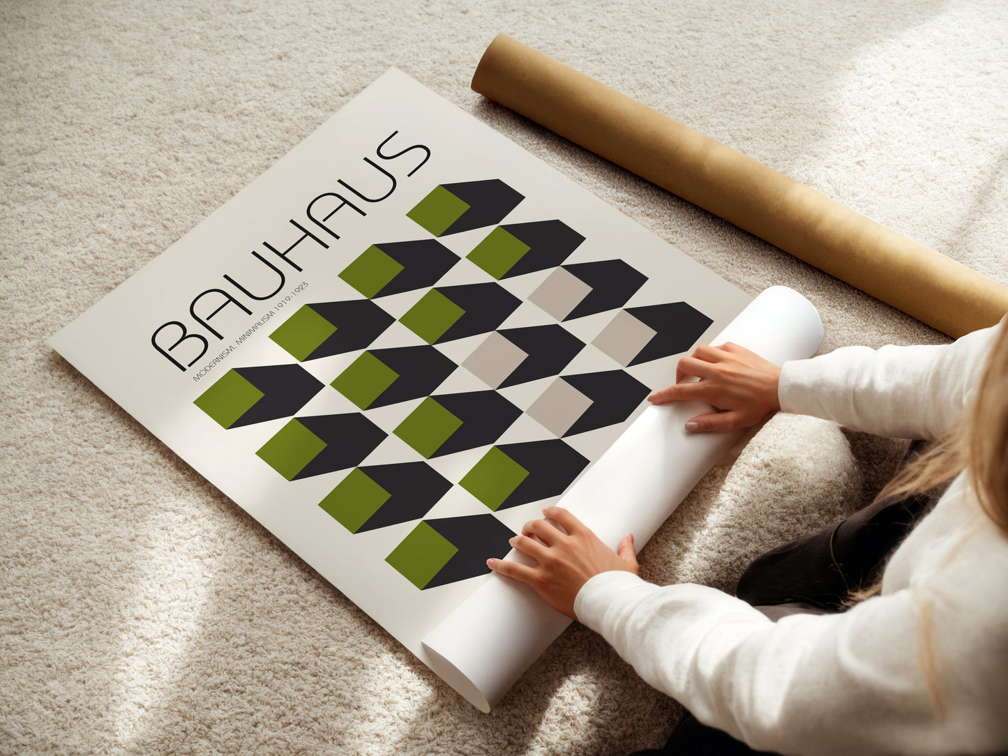 Person unrolling a Bauhaus-themed poster on a carpeted floor