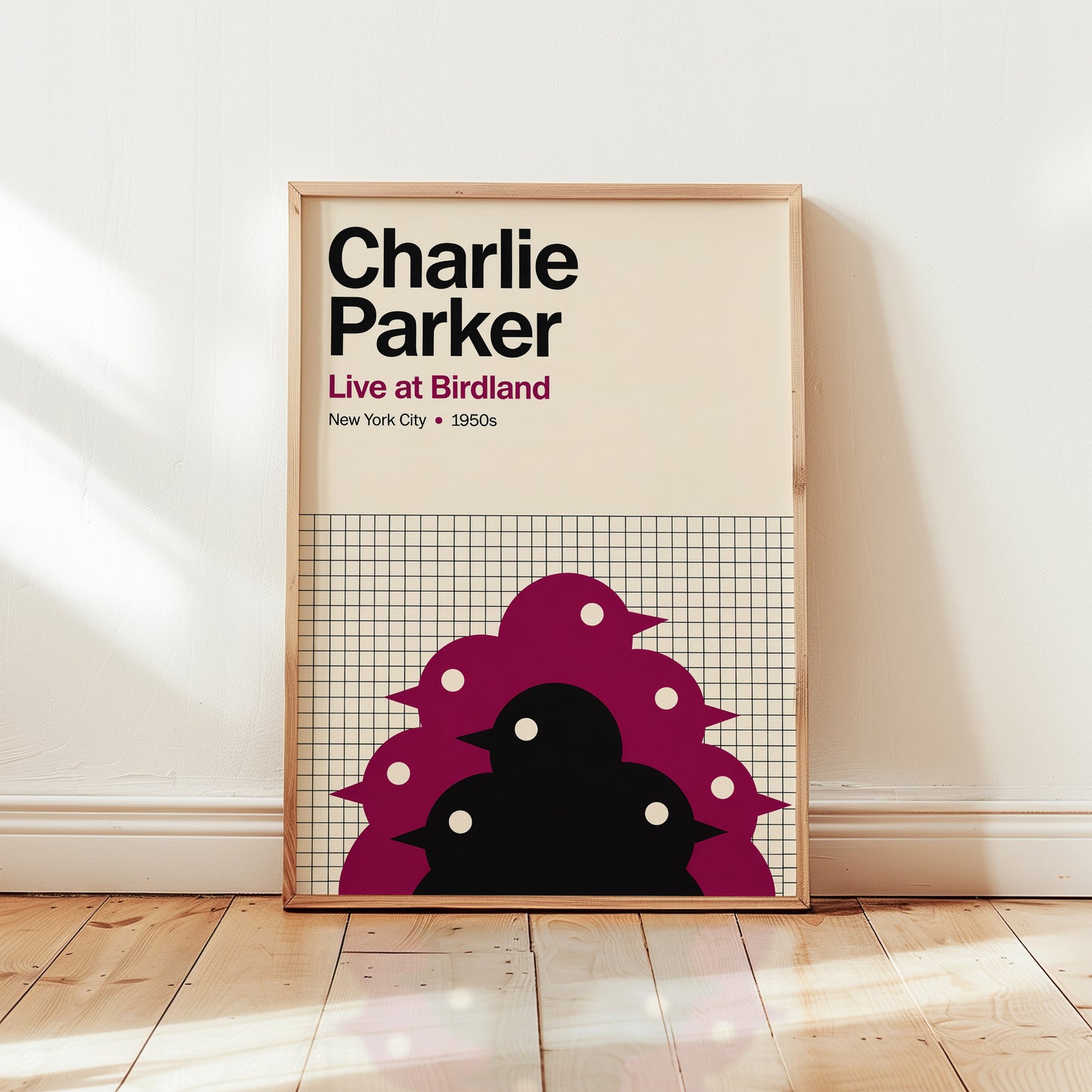 Framed poster of Charlie Parker with a design of birds on a grid background, placed on a wooden floor.