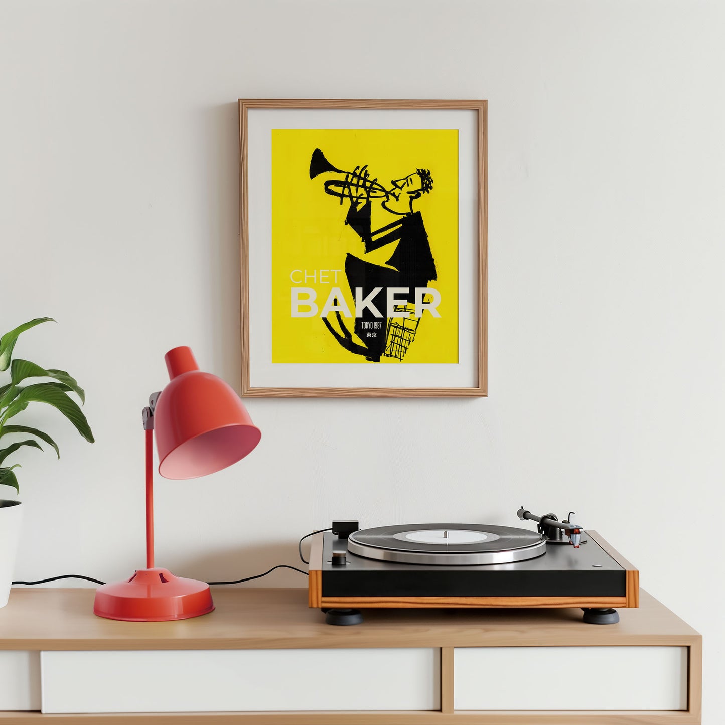 Turntable on a wooden shelf with a framed poster of a jazz musician and a red lamp.