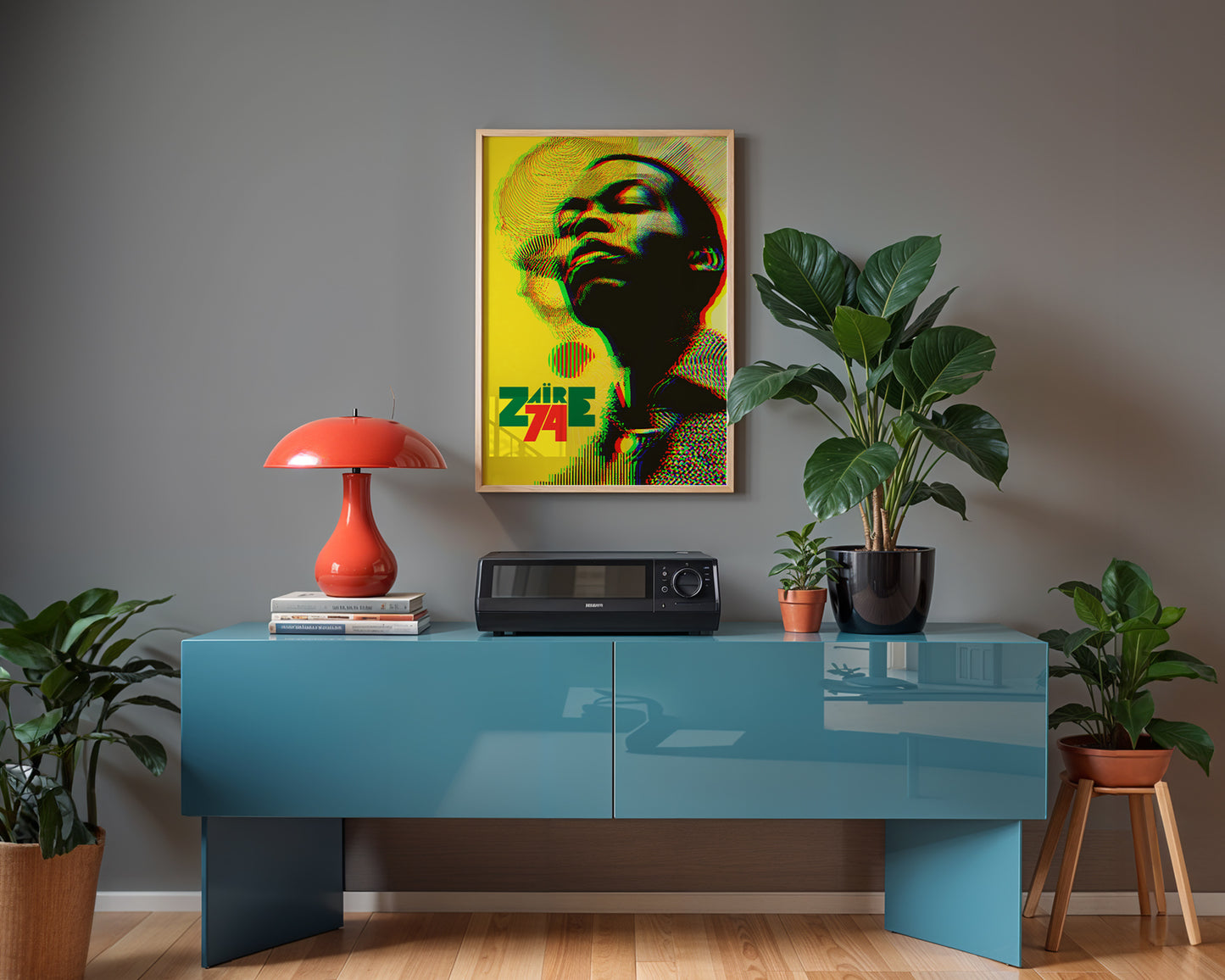 Modern interior with a blue console table, red lamp, and framed Fela Kuti artwork on a gray wall.