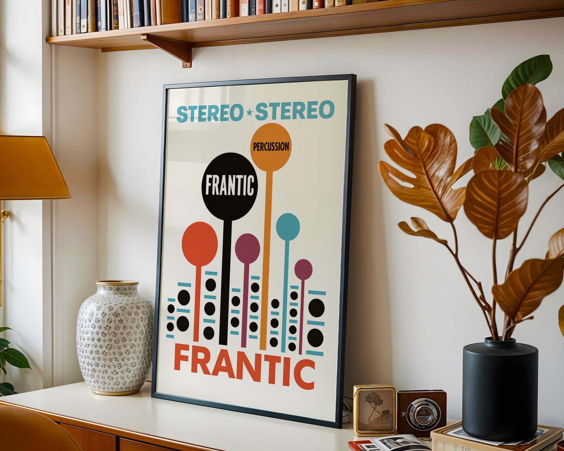 Framed poster with 'Stereo Stereo' and 'Frantic' text in a room with books, plants, and decor.