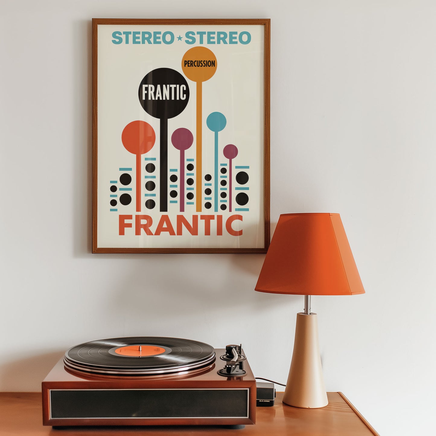 Framed poster with 'Stereo + Stereo' design above a record player on a wooden surface.