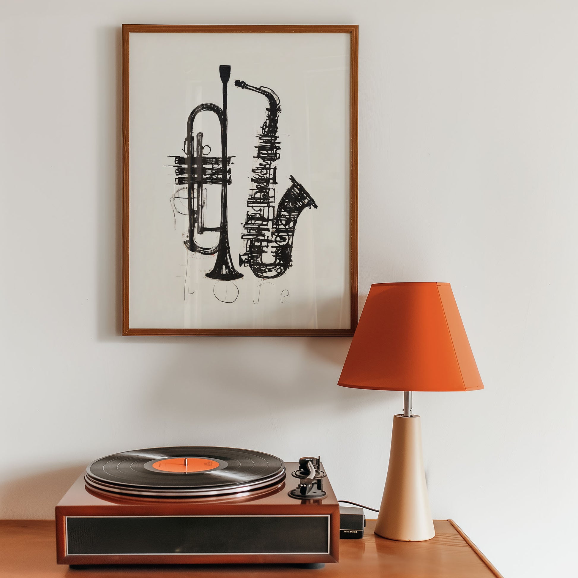 Turntable with a vinyl record, framed artwork of musical instruments, and an orange lamp on a wooden surface.
