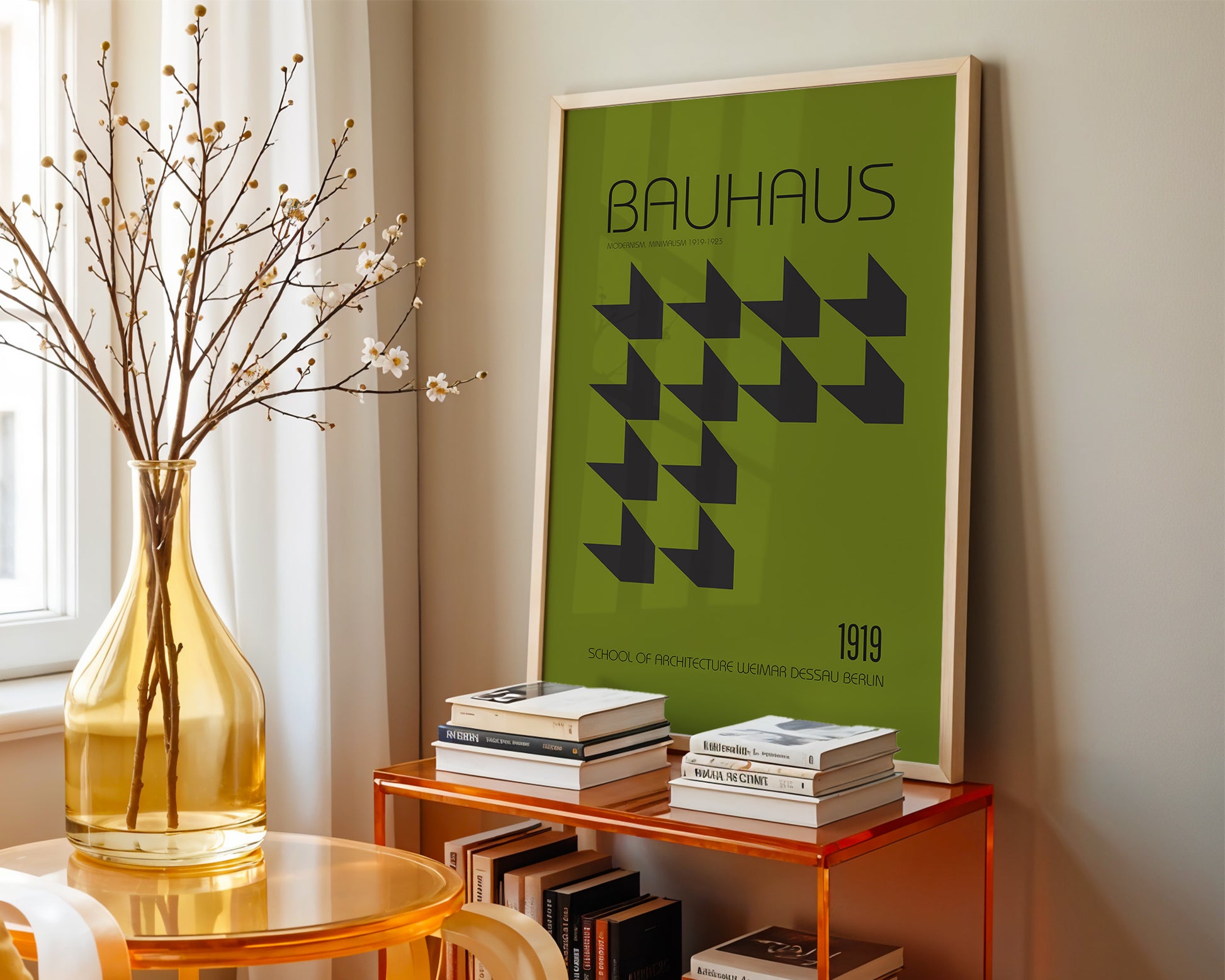 Framed green Bauhaus poster on a shelf with books and a vase in a room.