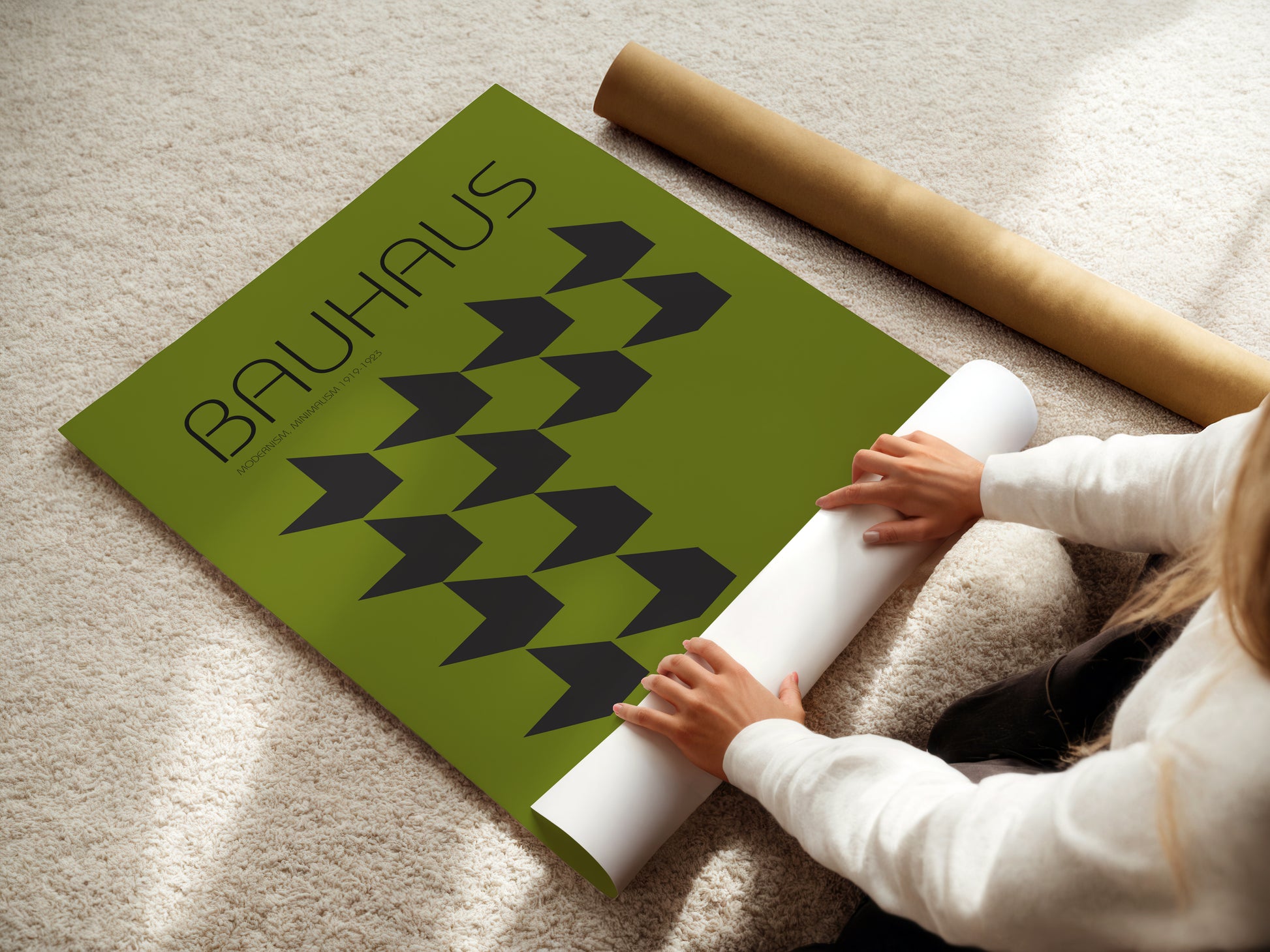 Person unrolling a green Bauhaus rug on a beige carpet