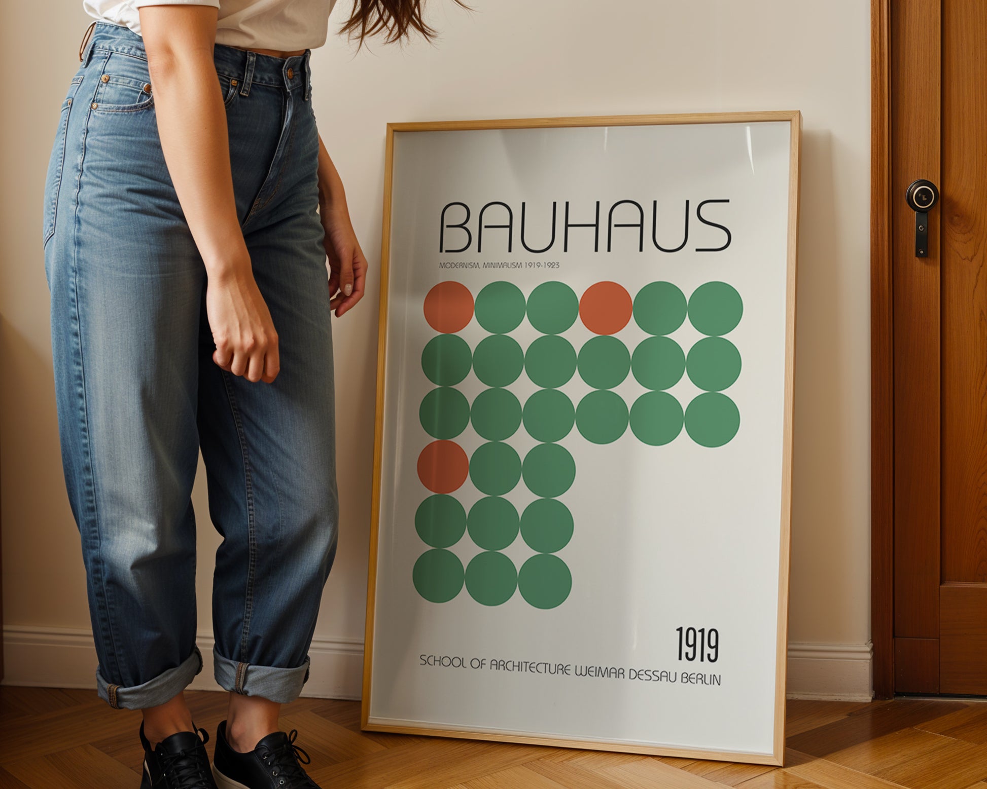 Person standing next to a Bauhaus poster with geometric design