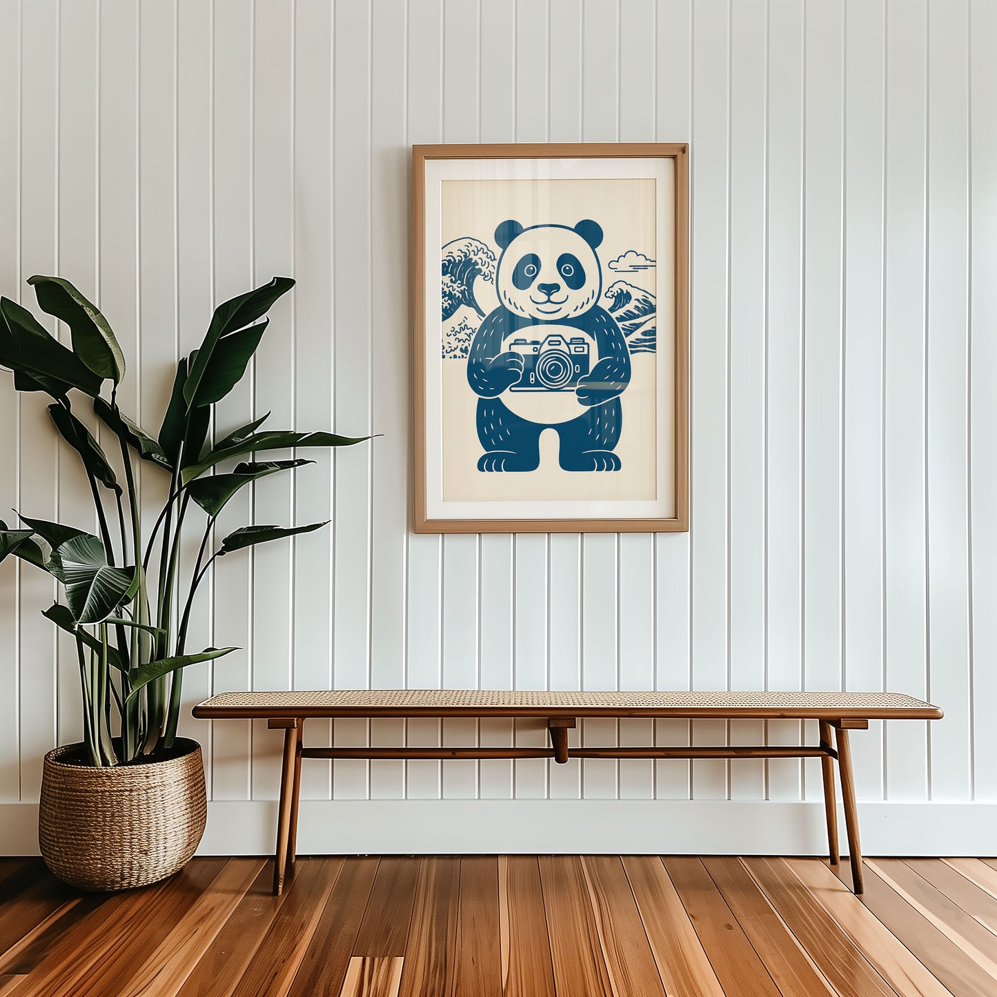 Framed artwork of a panda holding a camera on a wall above a wooden bench.