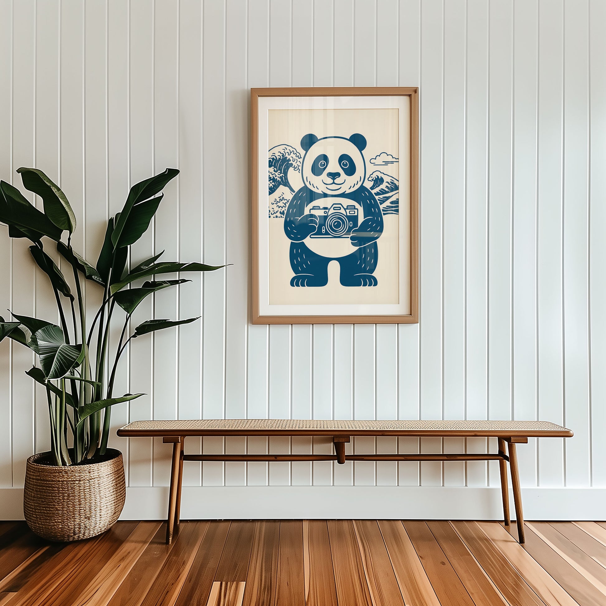 Framed artwork of a panda holding a camera on a wall above a wooden bench.