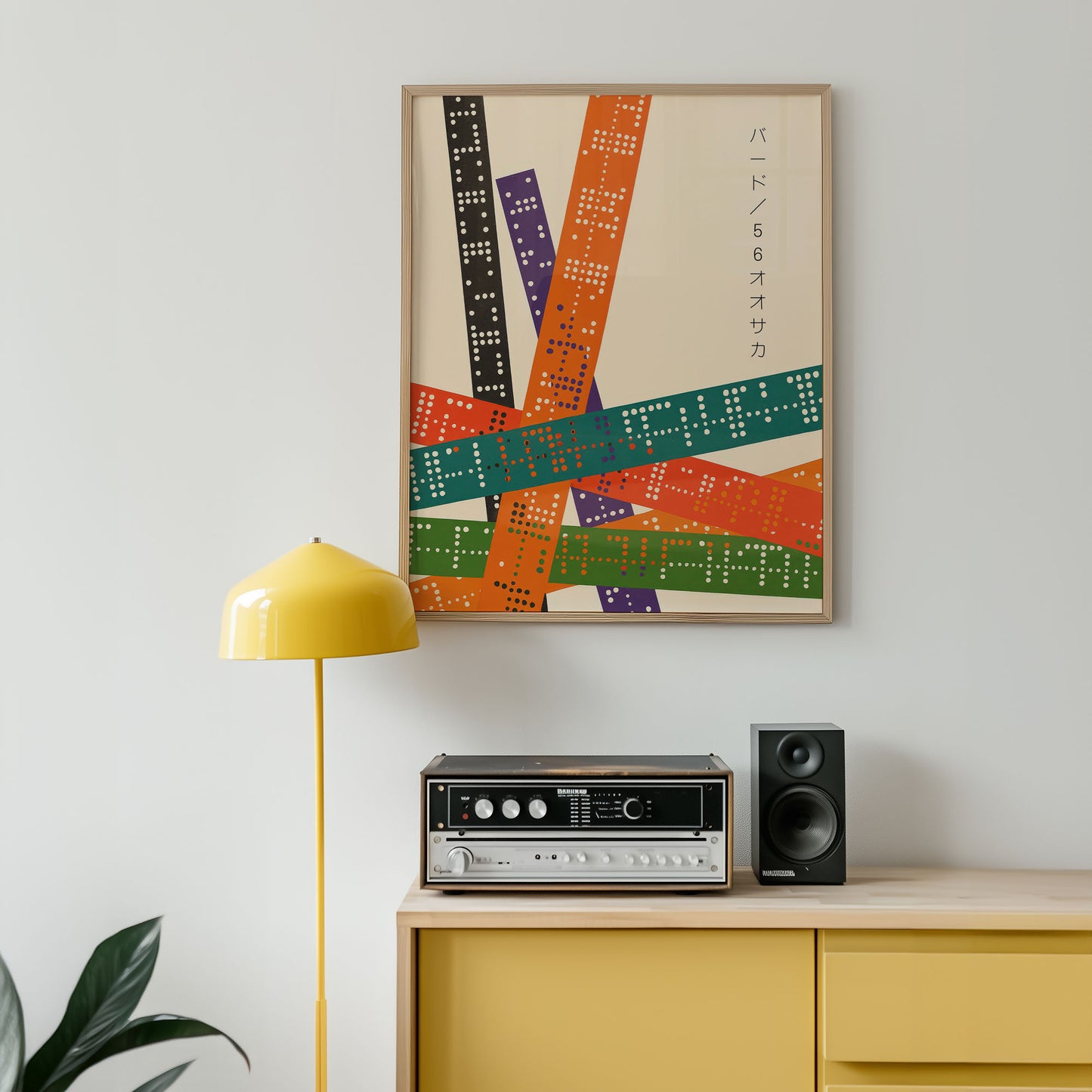 Colorful abstract art print on a wall above a yellow cabinet with stereo equipment.