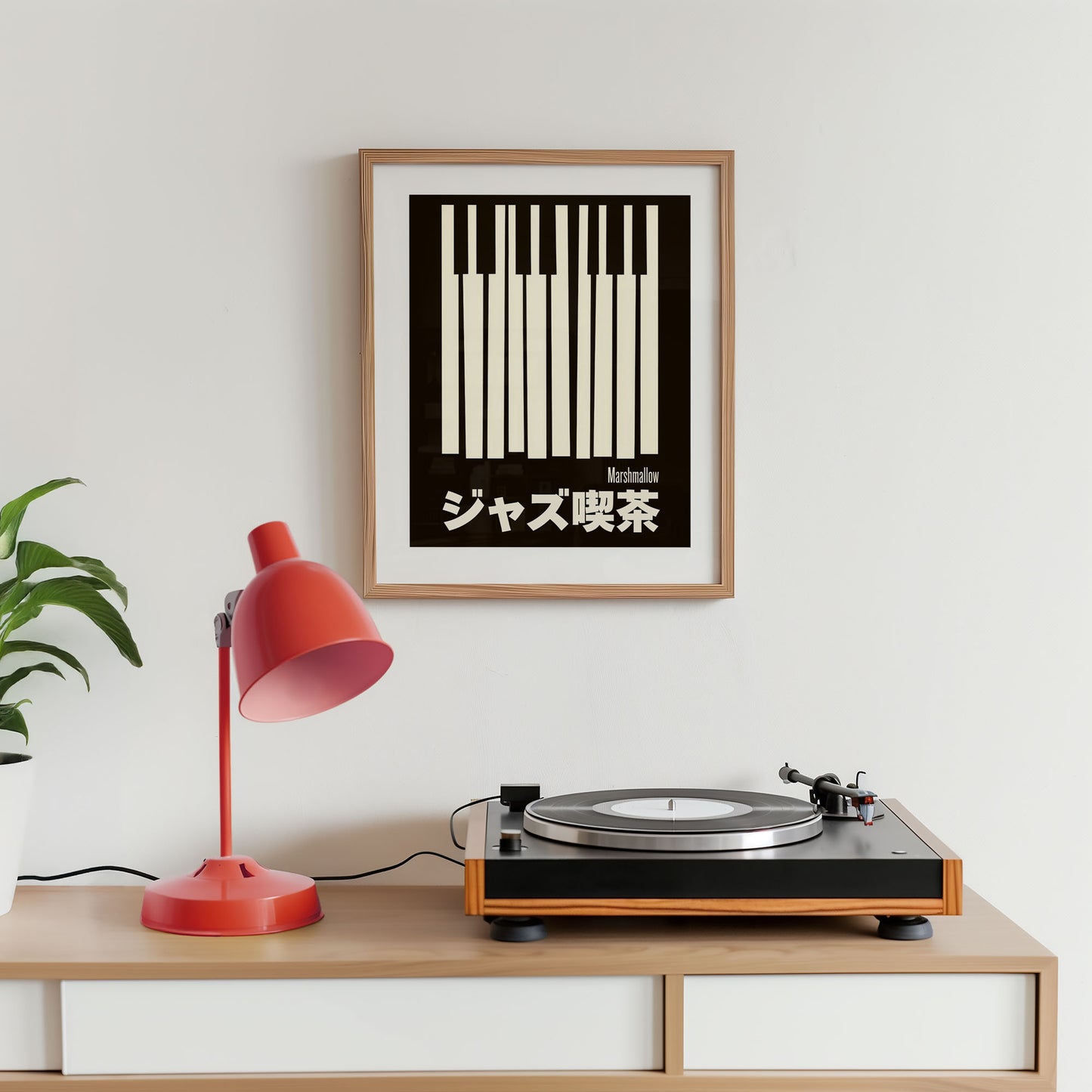 Turntable on a wooden shelf with a red lamp and framed poster on a white wall.