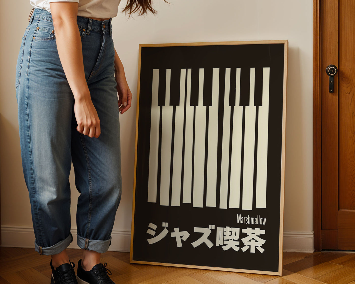 Person standing next to a framed black and white art print on a wall.
