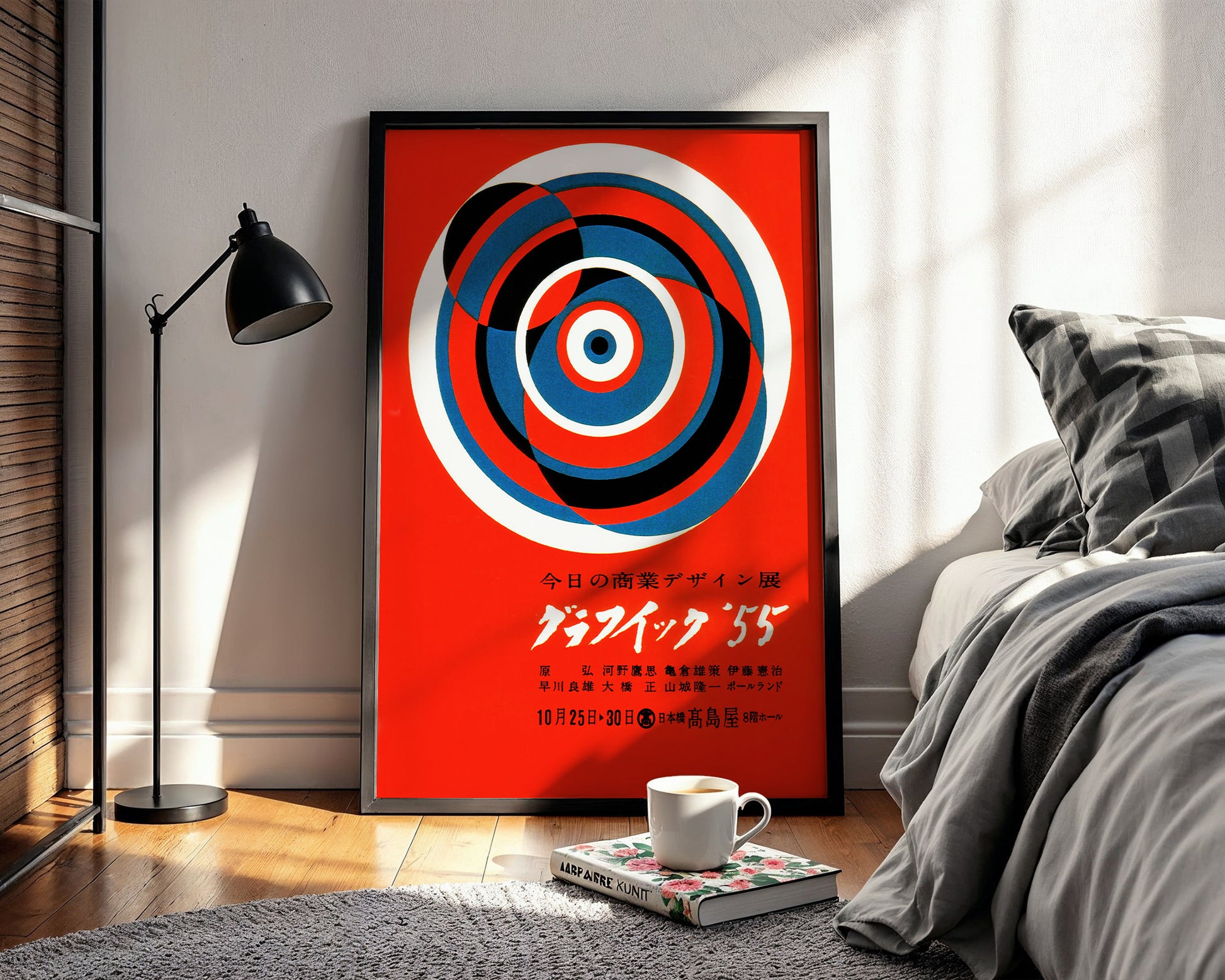 Mid-century Japanese graphic design poster displayed above a bed in minimalist interior setting.