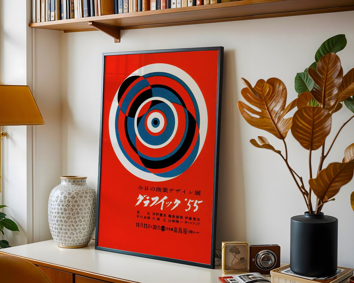 Graphic ’55 Japanese exhibition poster framed on a modern living room wall with bold red and concentric circle design.