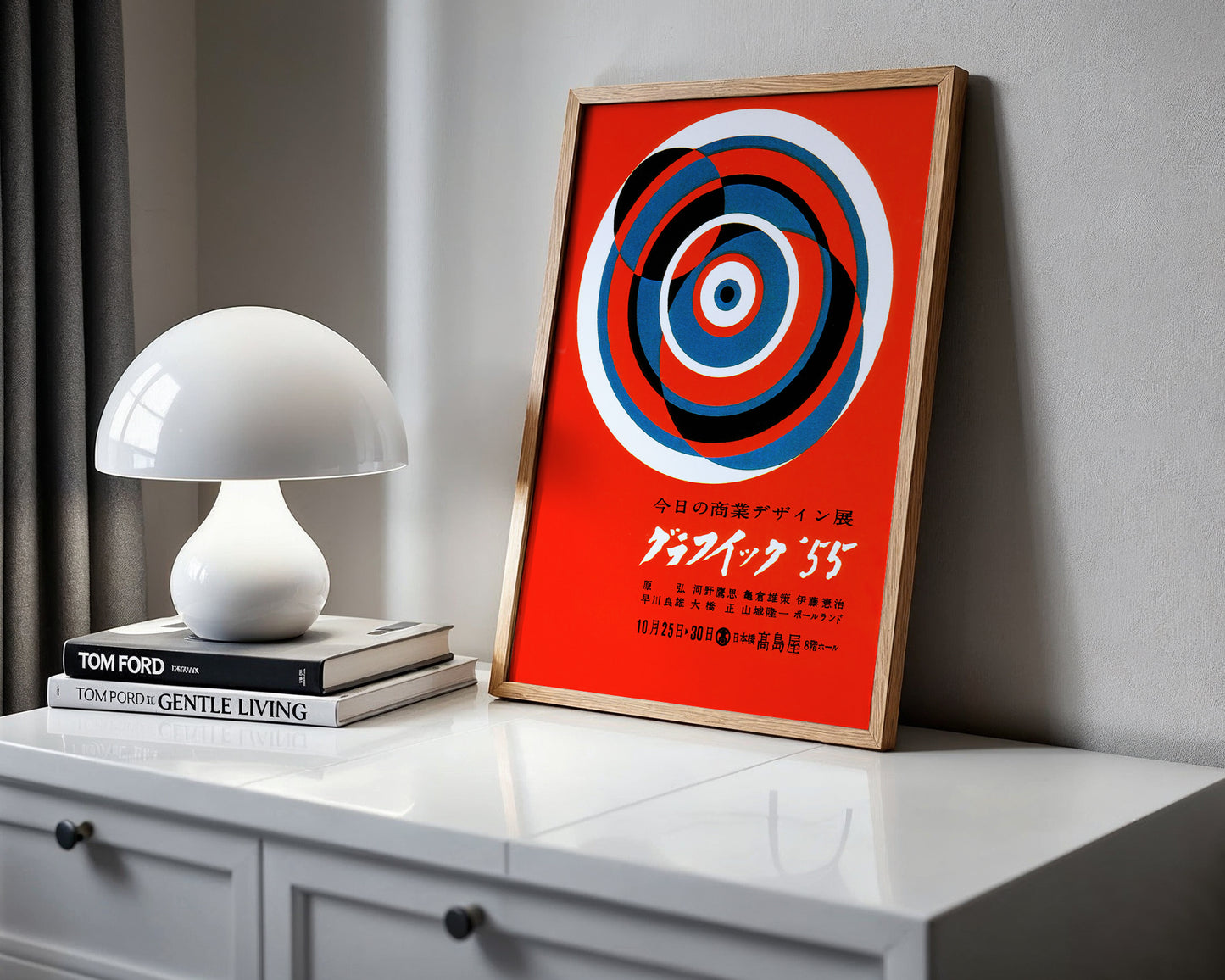 Framed abstract art on a shelf with a white lamp and books