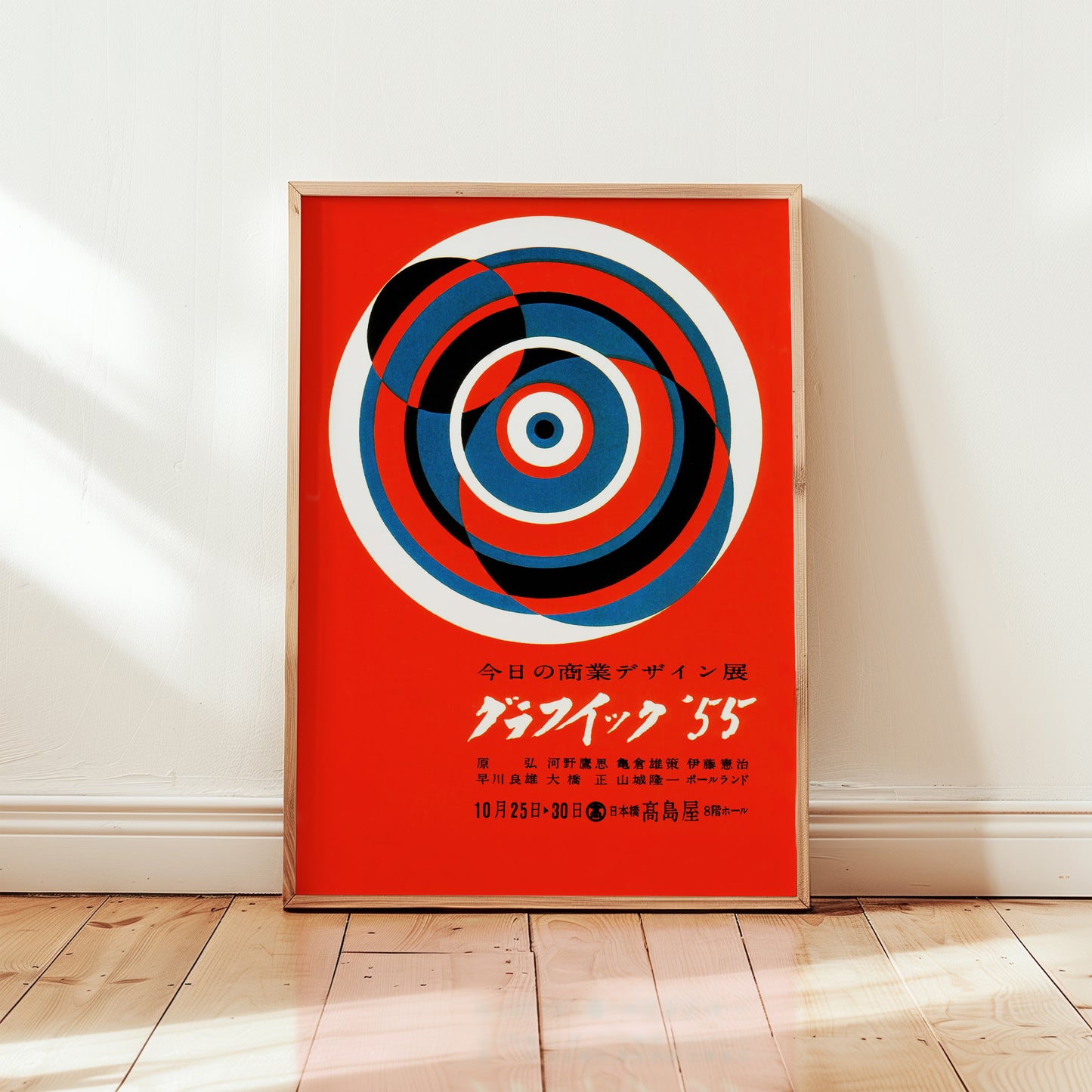 1955 Japanese graphic design exhibition poster featuring bold red background with abstract concentric circles in blue, black and white.