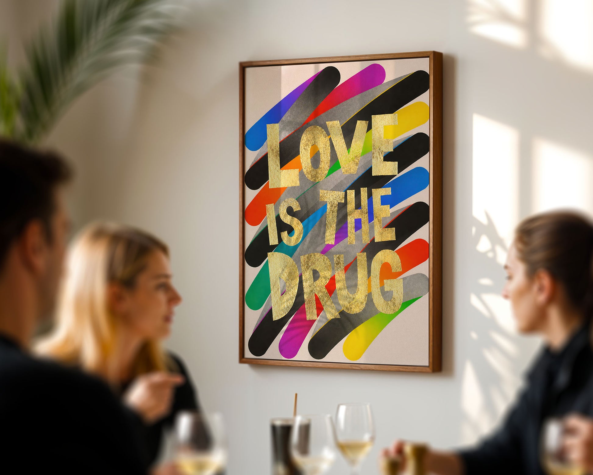 Colorful art print with 'Love is the Drug' on a wall in a social setting.