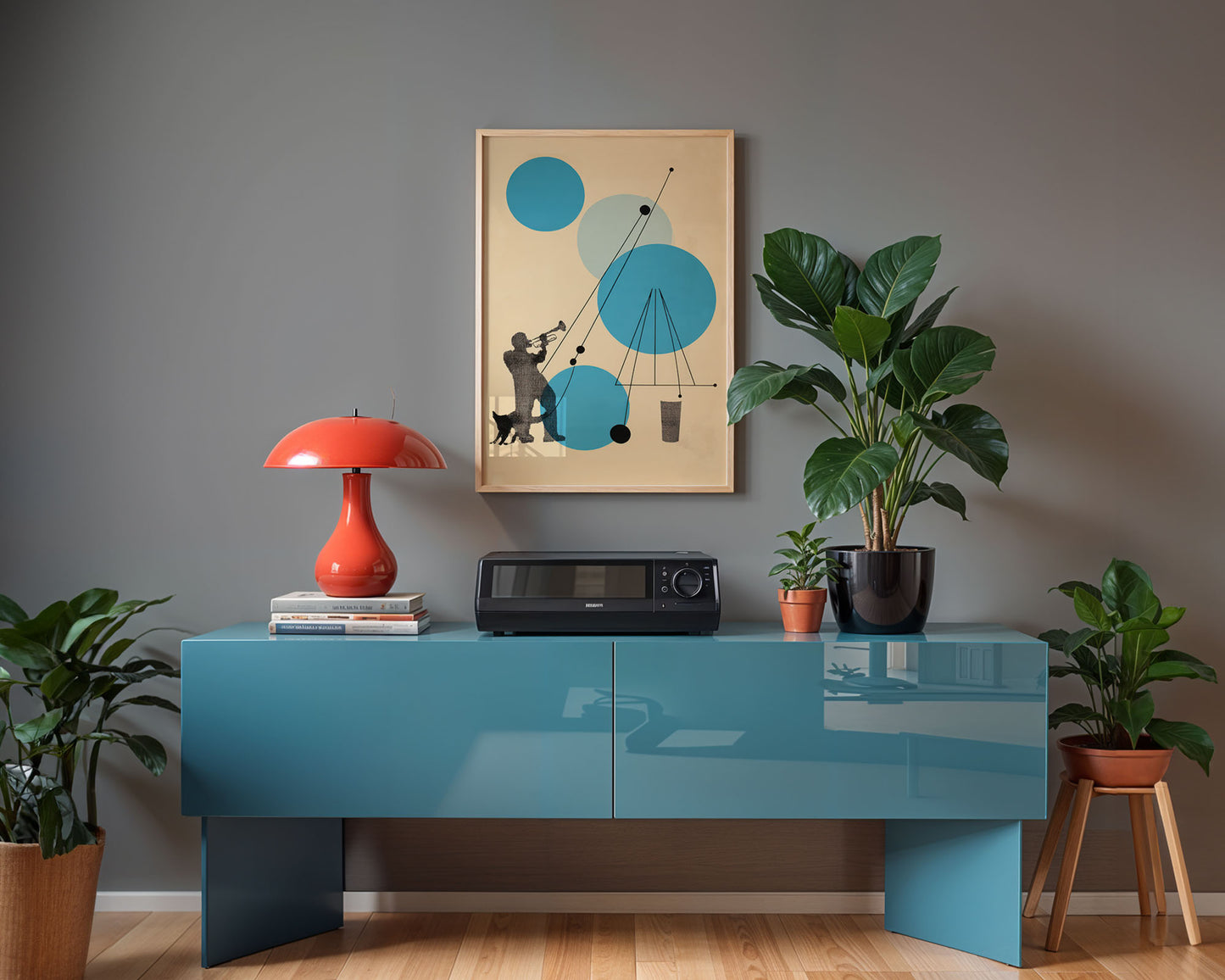 Modern interior with a blue console table, red lamp, and framed artwork on a gray wall.