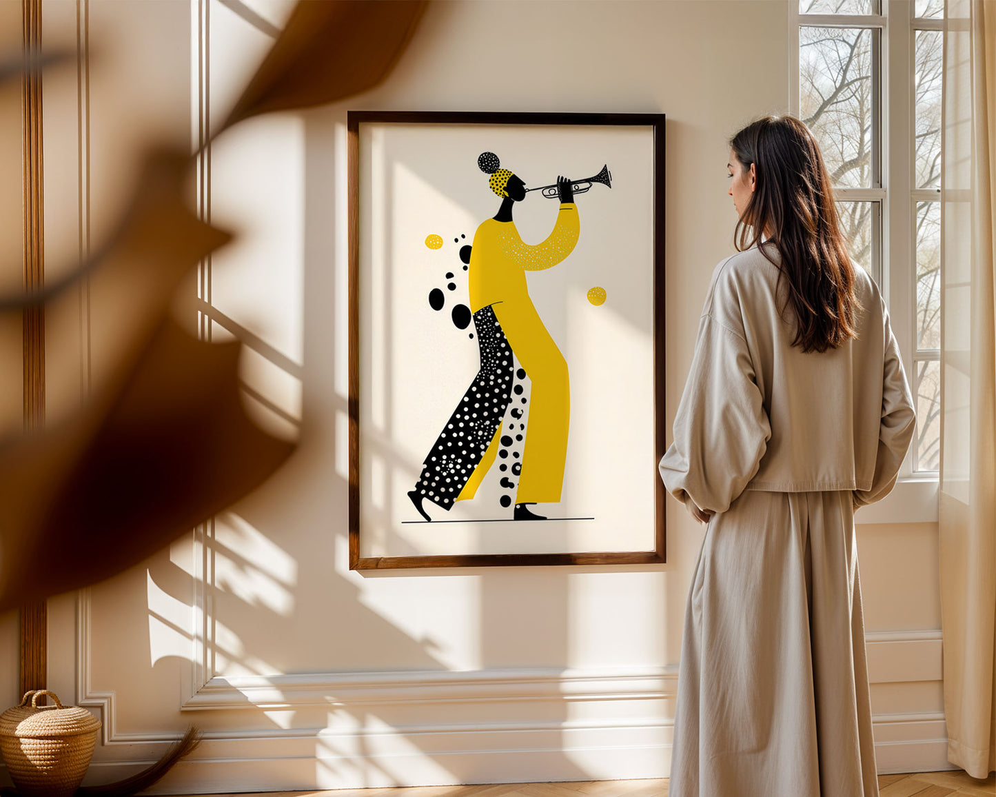 Woman standing in a room looking at a framed artwork of two stylized figures playing instruments.