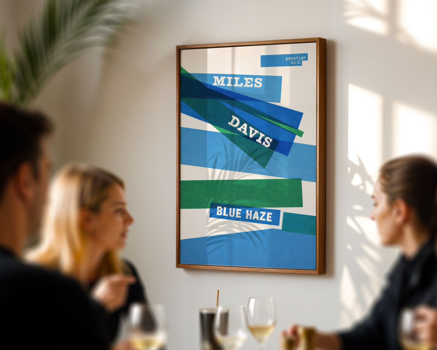 Framed poster with 'Miles Davis Blue Haze' design on a wall in a social setting.
