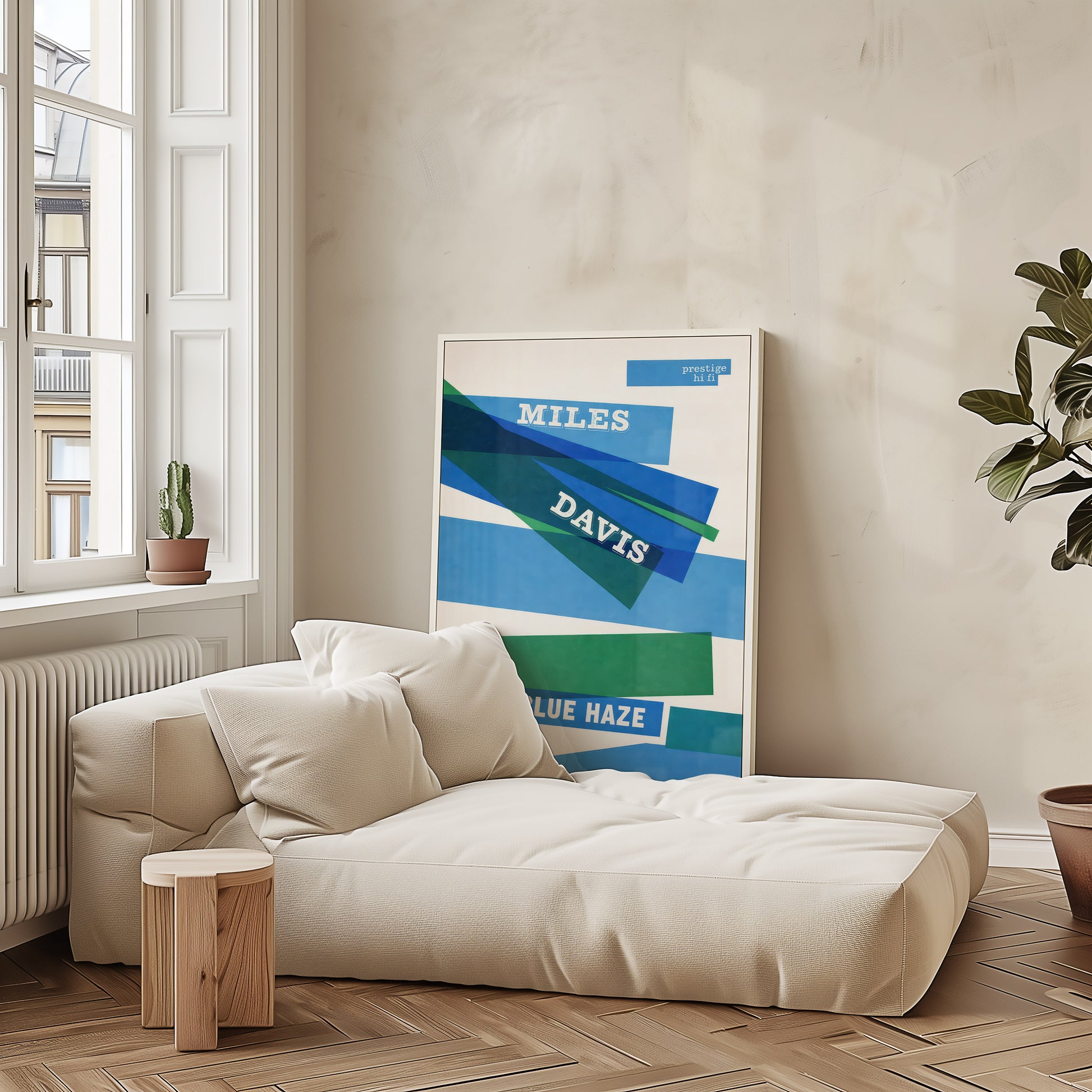 Beige sofa in a room with a framed poster of Miles Davis on the wall.
