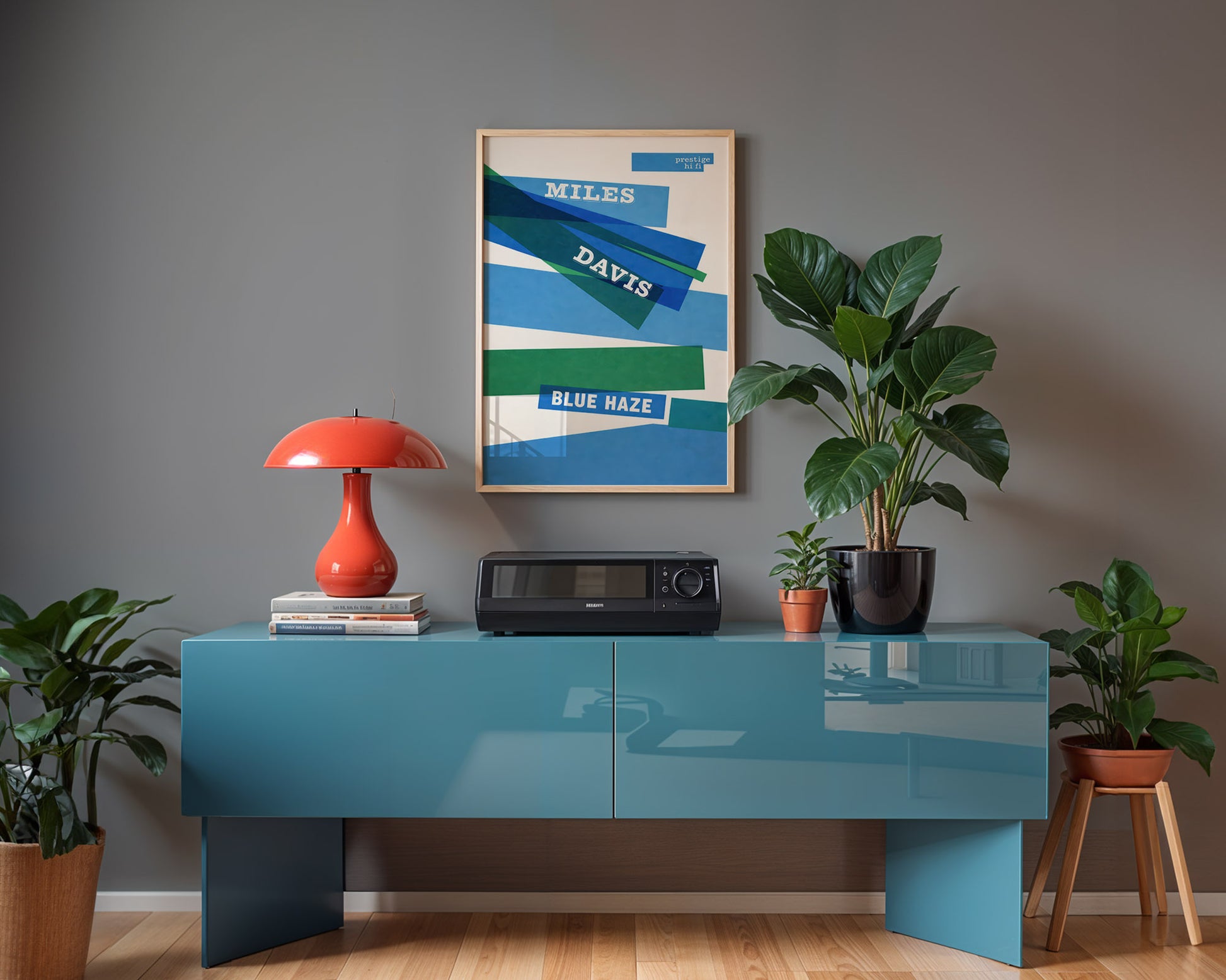 Modern interior with a blue console table, red lamp, and framed artwork on a gray wall.
