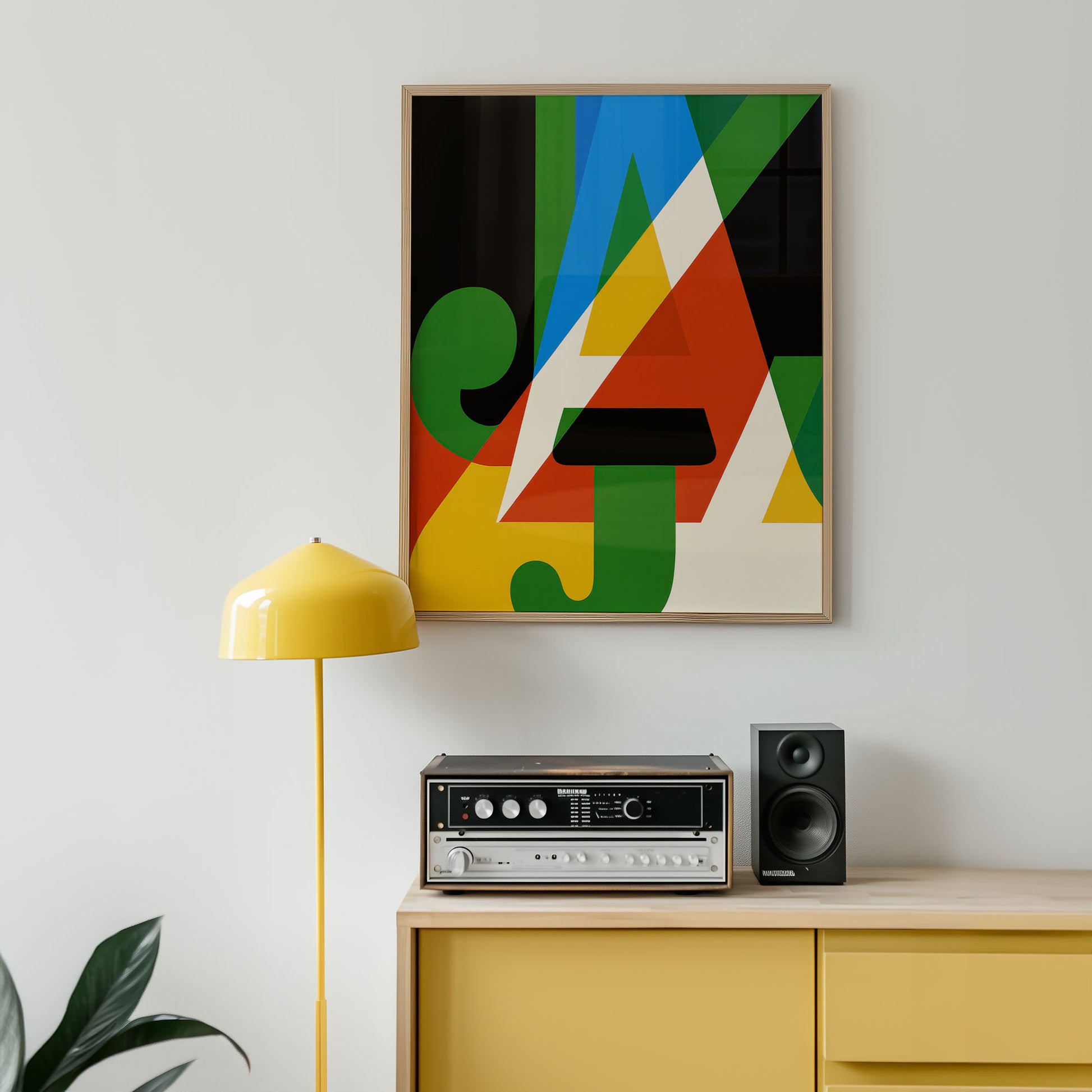 Colorful abstract art piece on a wall above a yellow cabinet with electronic equipment.