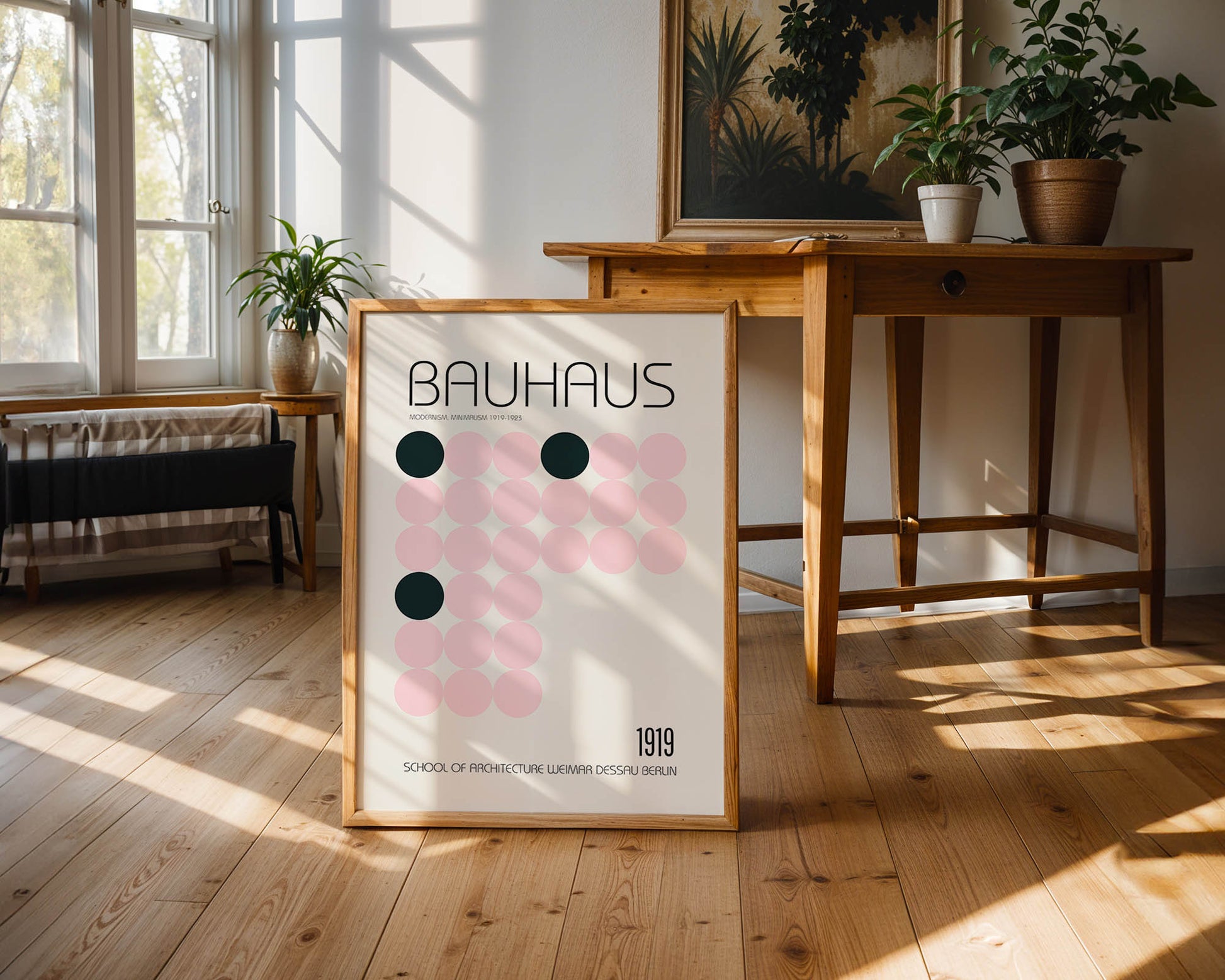 Framed Bauhaus poster on a wooden floor with a table and plants in the background