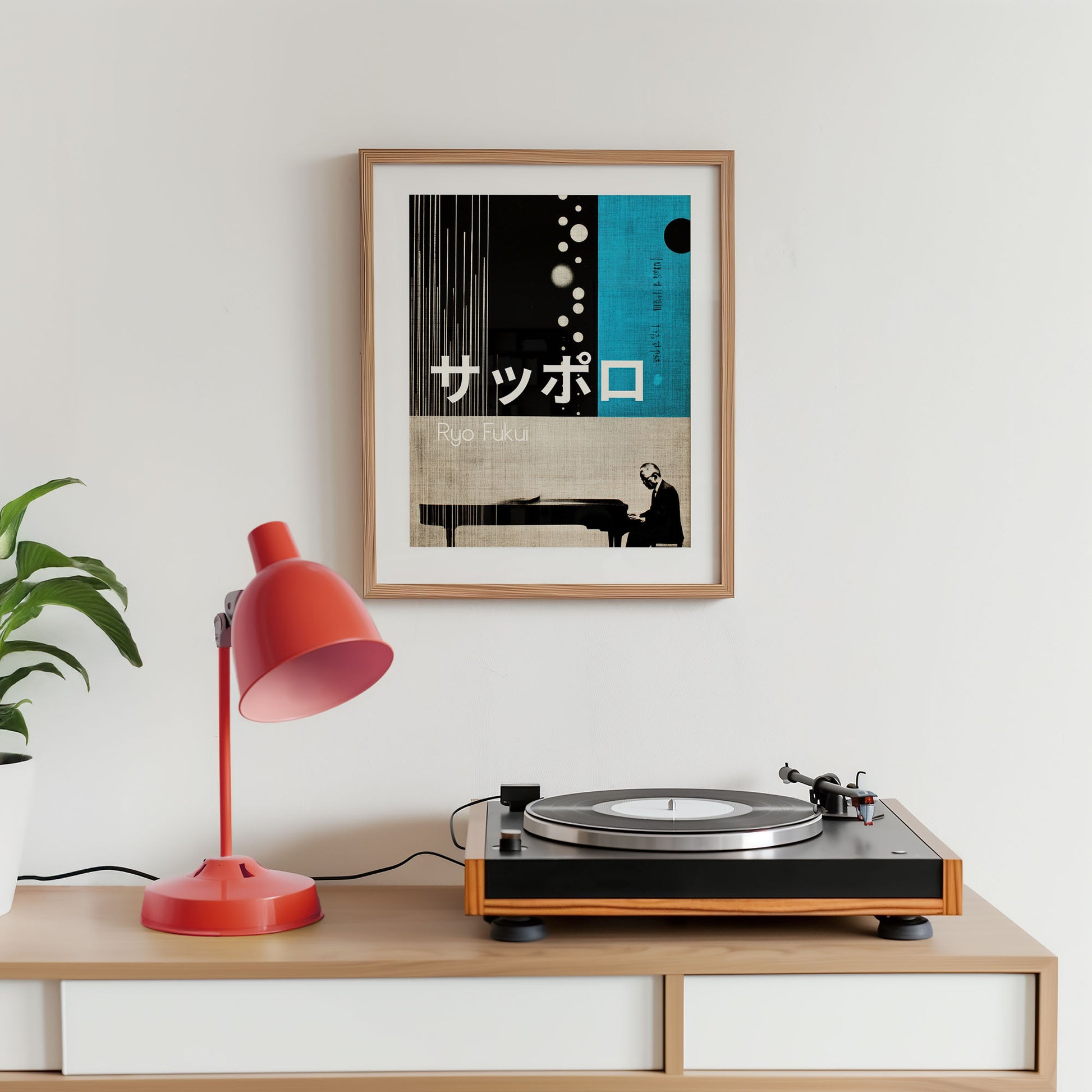 Turntable on a wooden shelf with a red lamp and framed poster on a white wall.