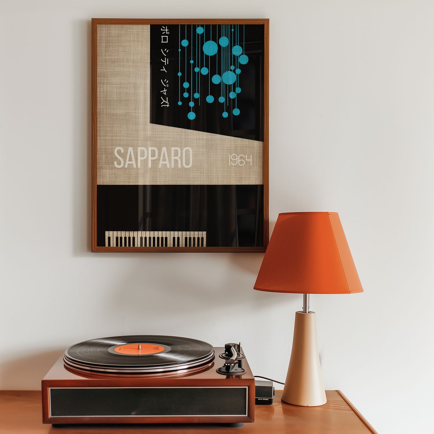 Framed poster above a vintage turntable with an orange lamp on a wooden surface.