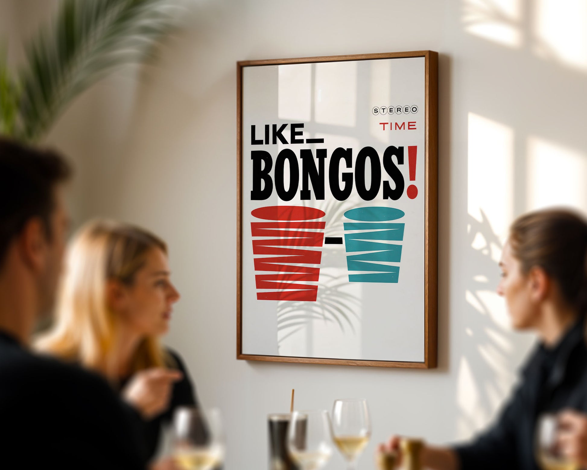 Framed poster with 'Like Bongos!' text and cup graphics on a wall in a social setting.