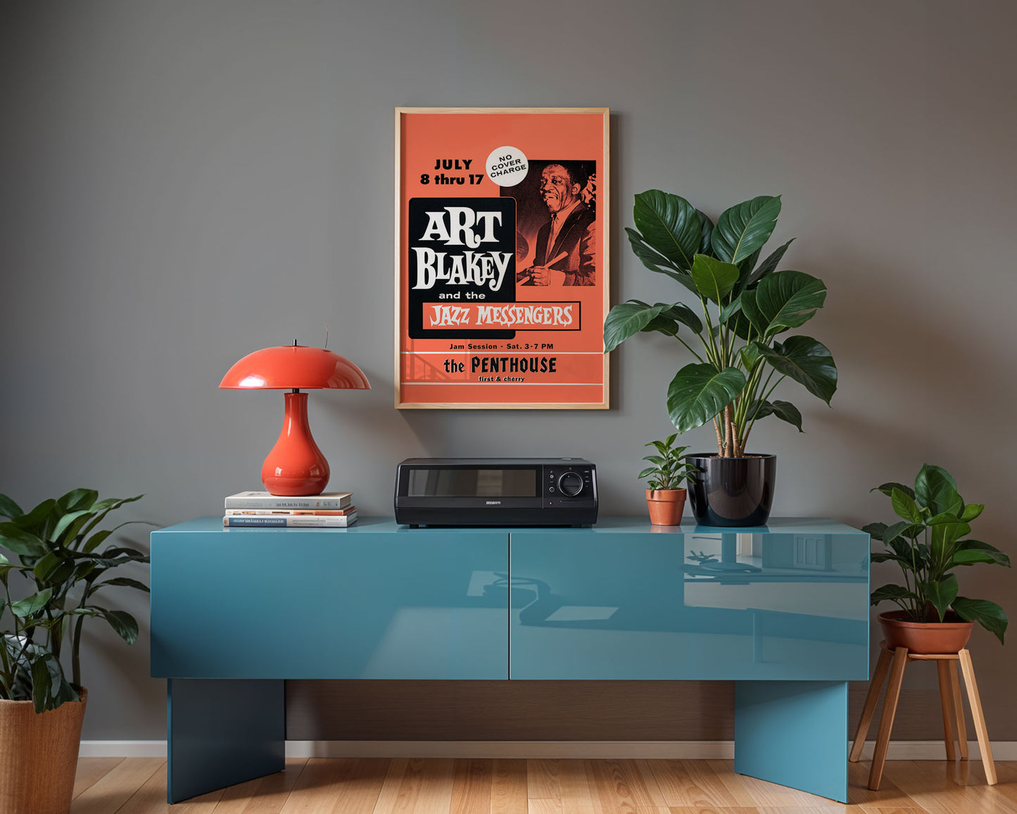 Modern interior with a blue console table, red lamp, and jazz poster on a gray wall.