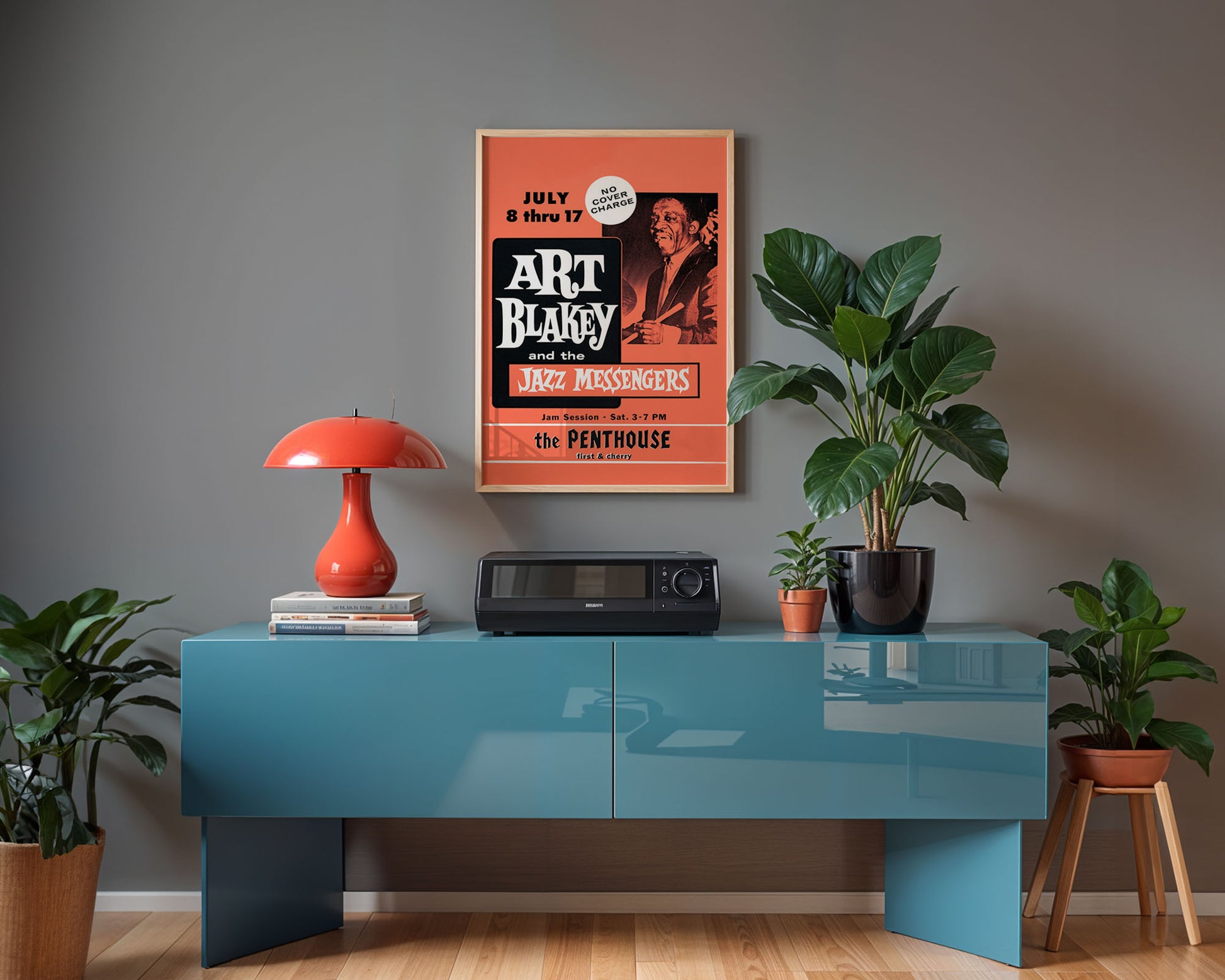 Modern interior with a blue console table, red lamp, and jazz poster on a gray wall.