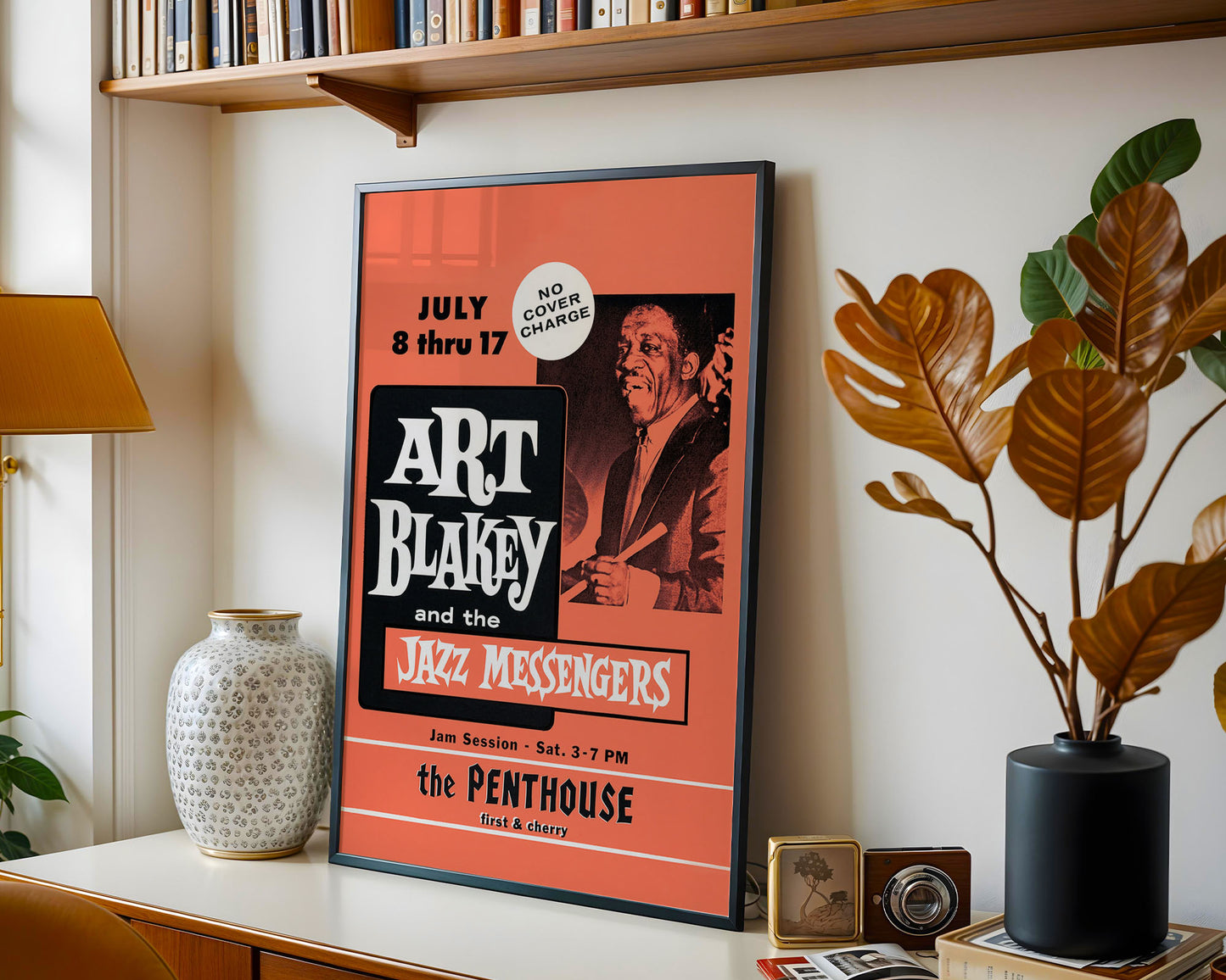 Framed poster of Art Blakey and the Jazz Messengers on a shelf with decorative items.