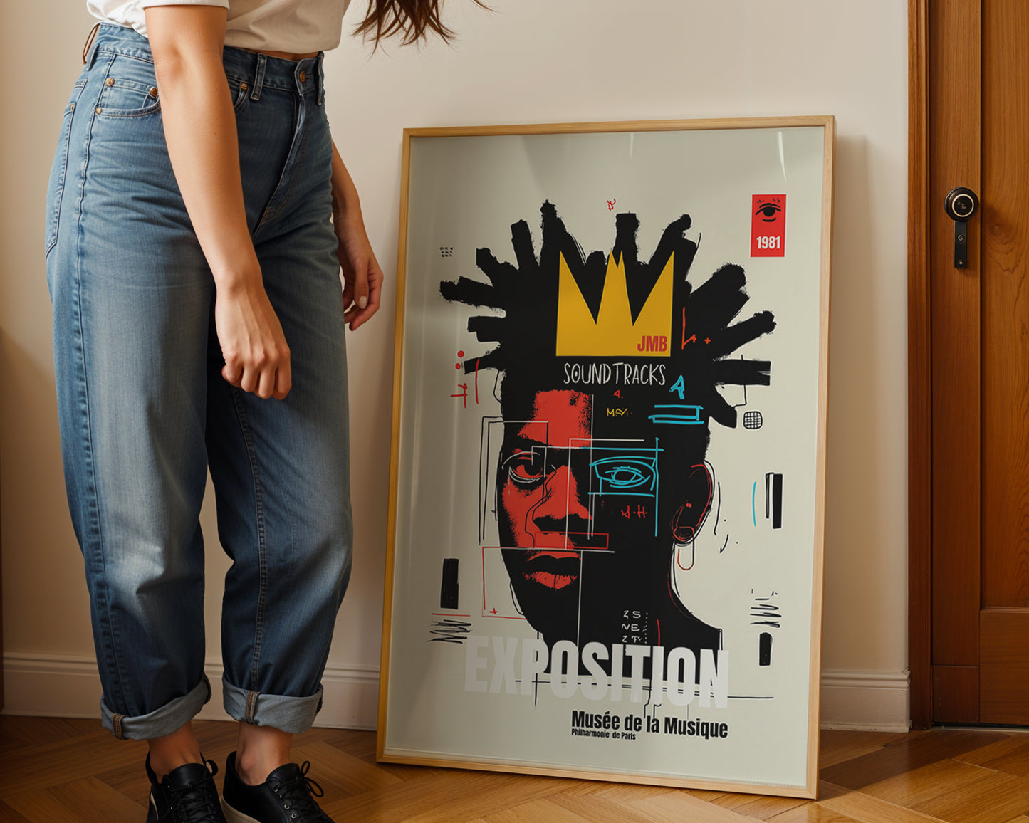 Person standing next to a framed poster of a stylized face with text on a wall.