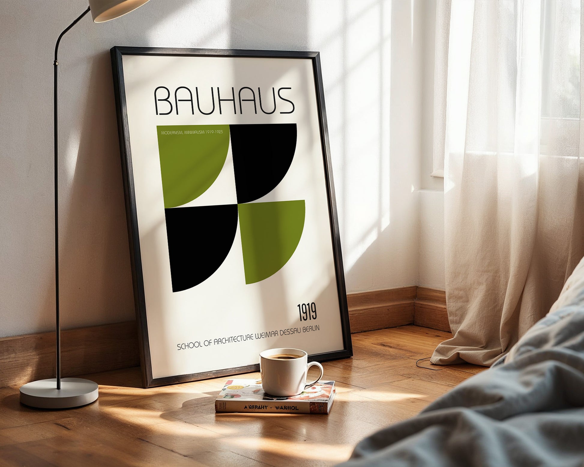 Framed Bauhaus poster on a wall with a cup and book on a surface below.