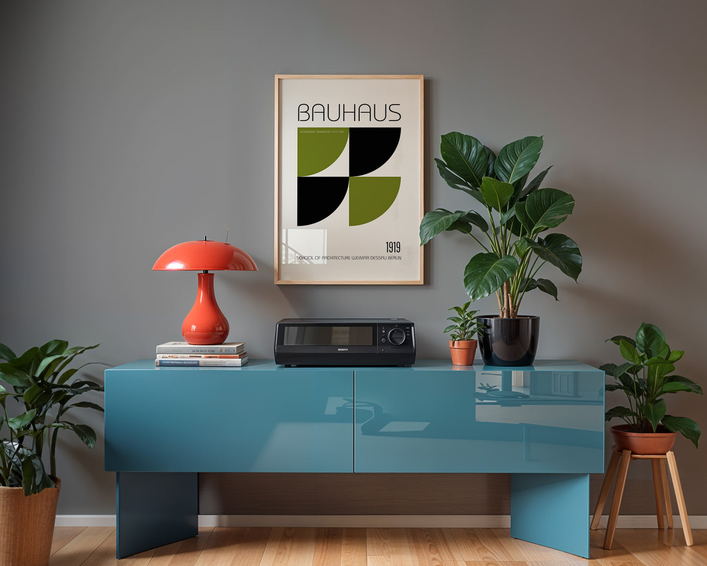 Modern interior with a blue console table, red lamp, and Bauhaus poster on a gray wall.