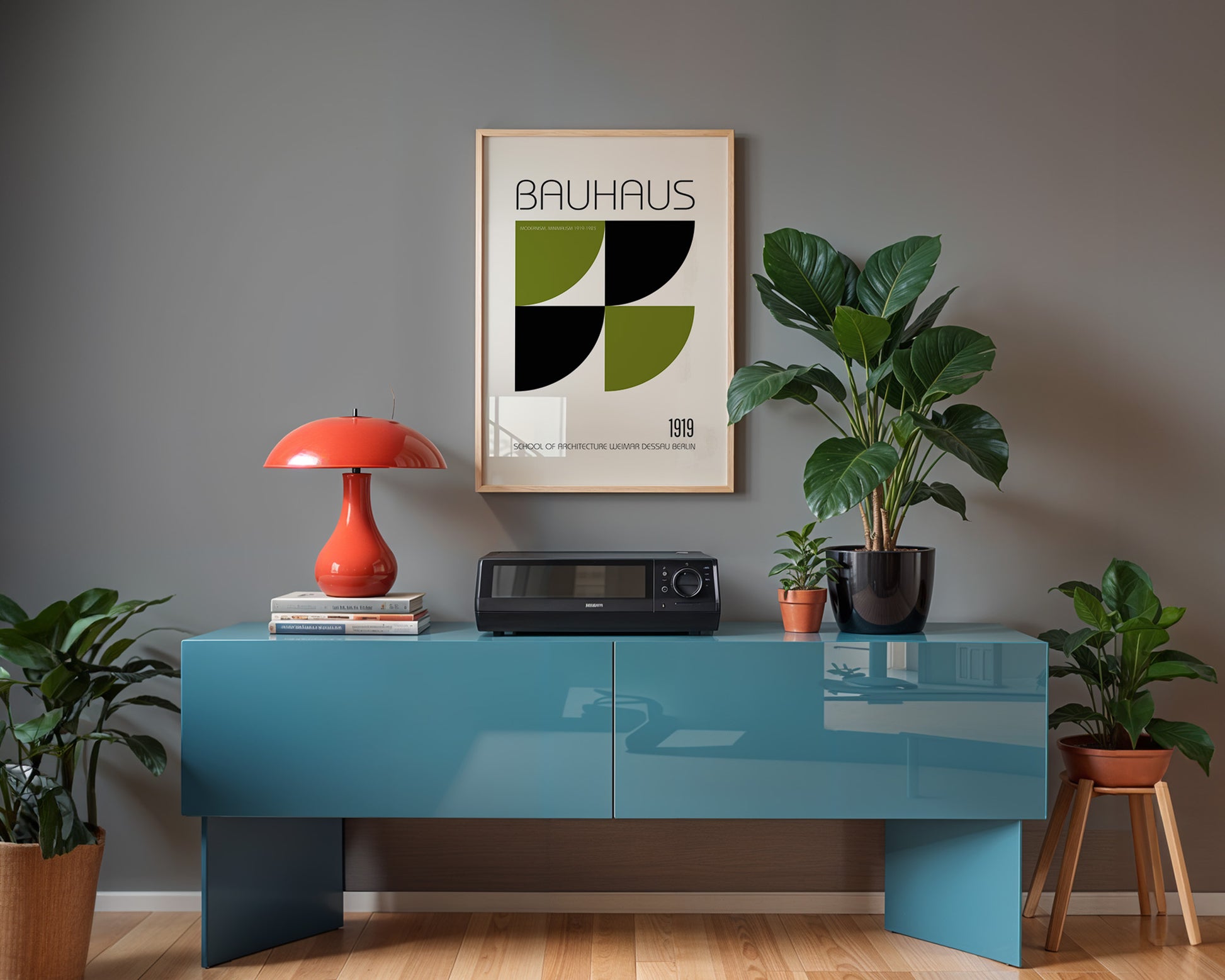 Modern interior with a blue console table, red lamp, and Bauhaus poster on a gray wall.