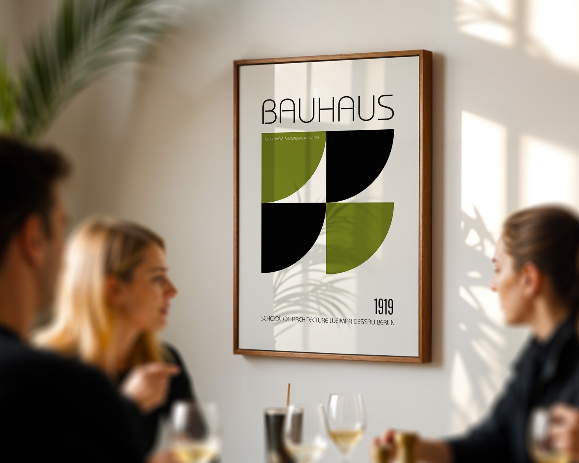 Framed Bauhaus poster on a wall with people socializing below