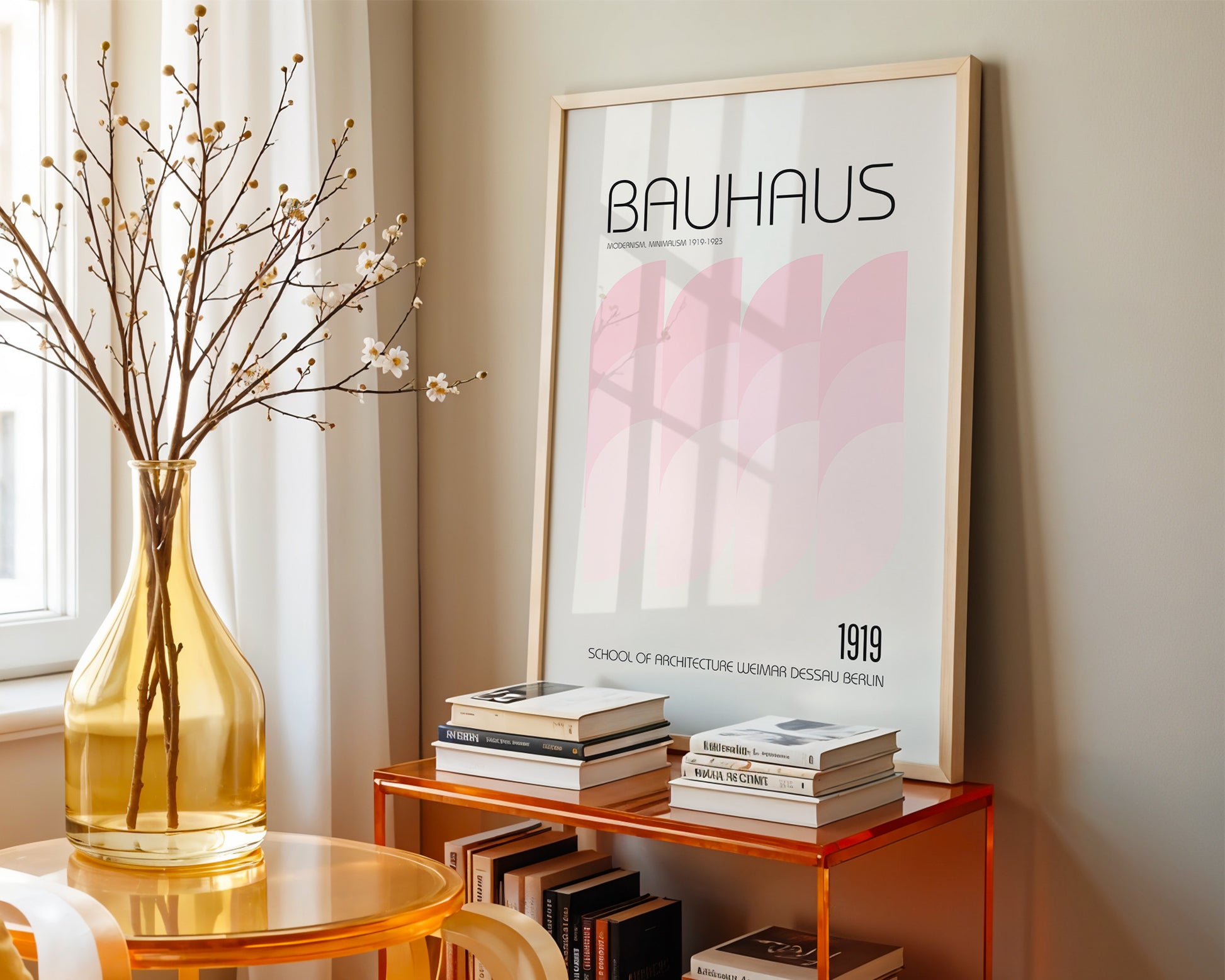 Framed Bauhaus poster on a shelf with books and a vase in a room.