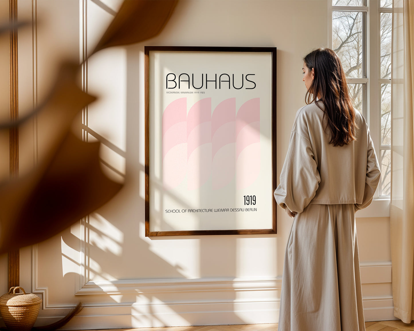 Woman standing in a room with a 'Bauhaus' poster on the wall