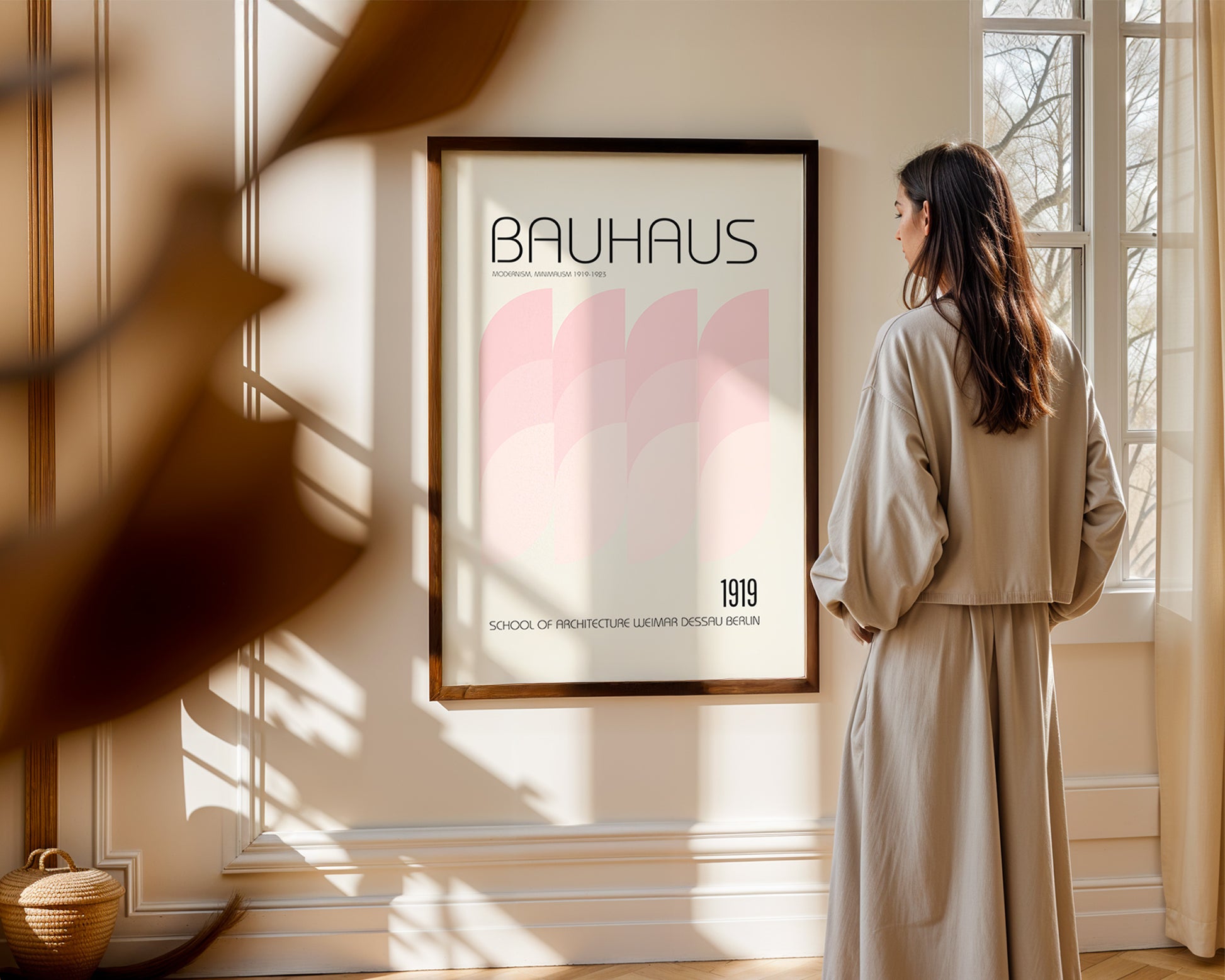 Woman standing in a room with a 'Bauhaus' poster on the wall