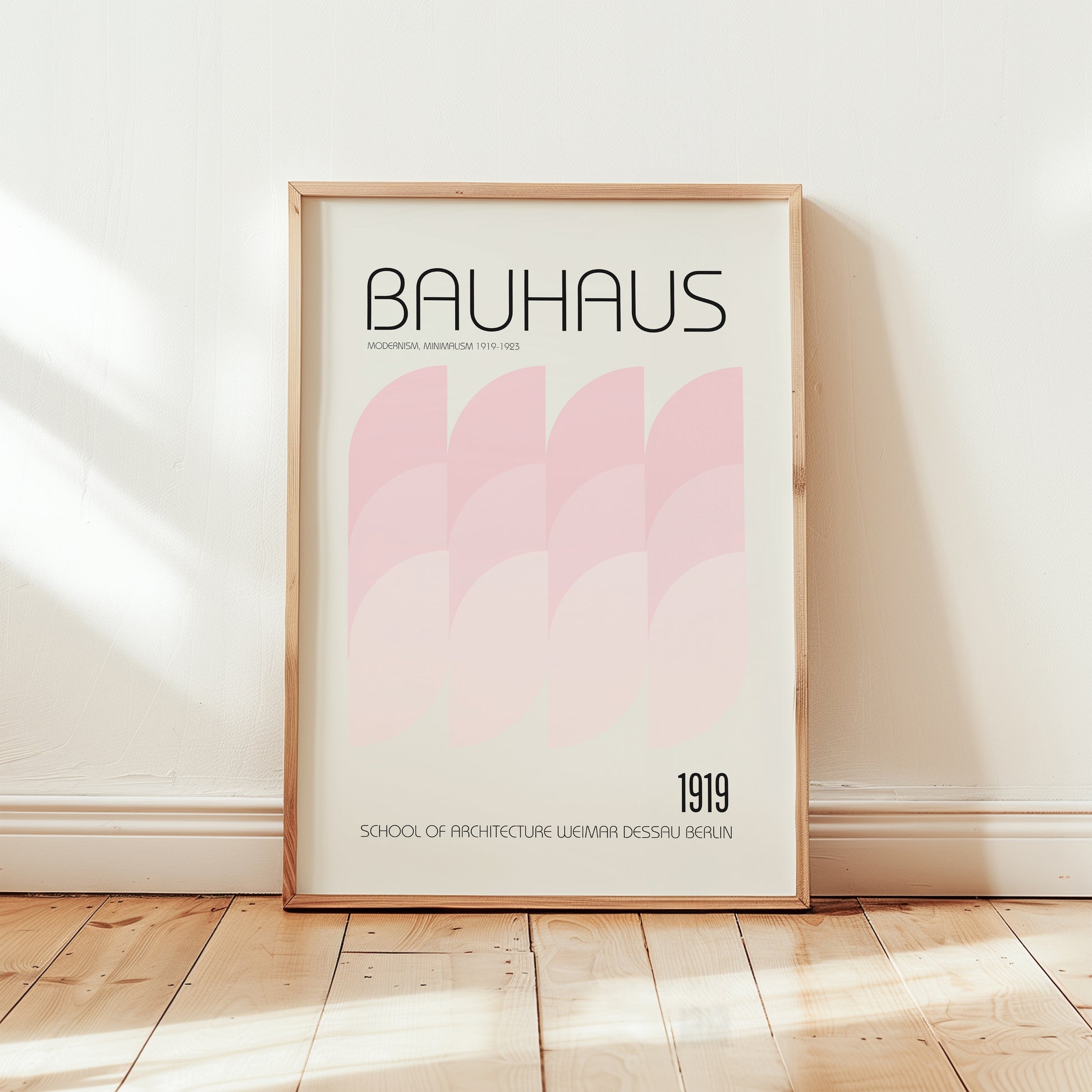 Bauhaus 1919 modernism poster framed in light wood, displayed in a minimalist interior with soft pink geometric design.