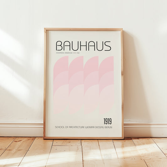 Bauhaus 1919 modernism poster framed in light wood, displayed in a minimalist interior with soft pink geometric design.