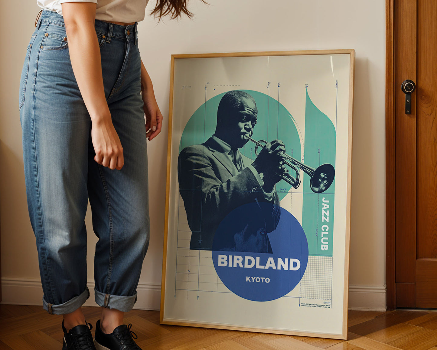 Person standing next to a framed poster of a jazz musician at Birdland Kyoto.