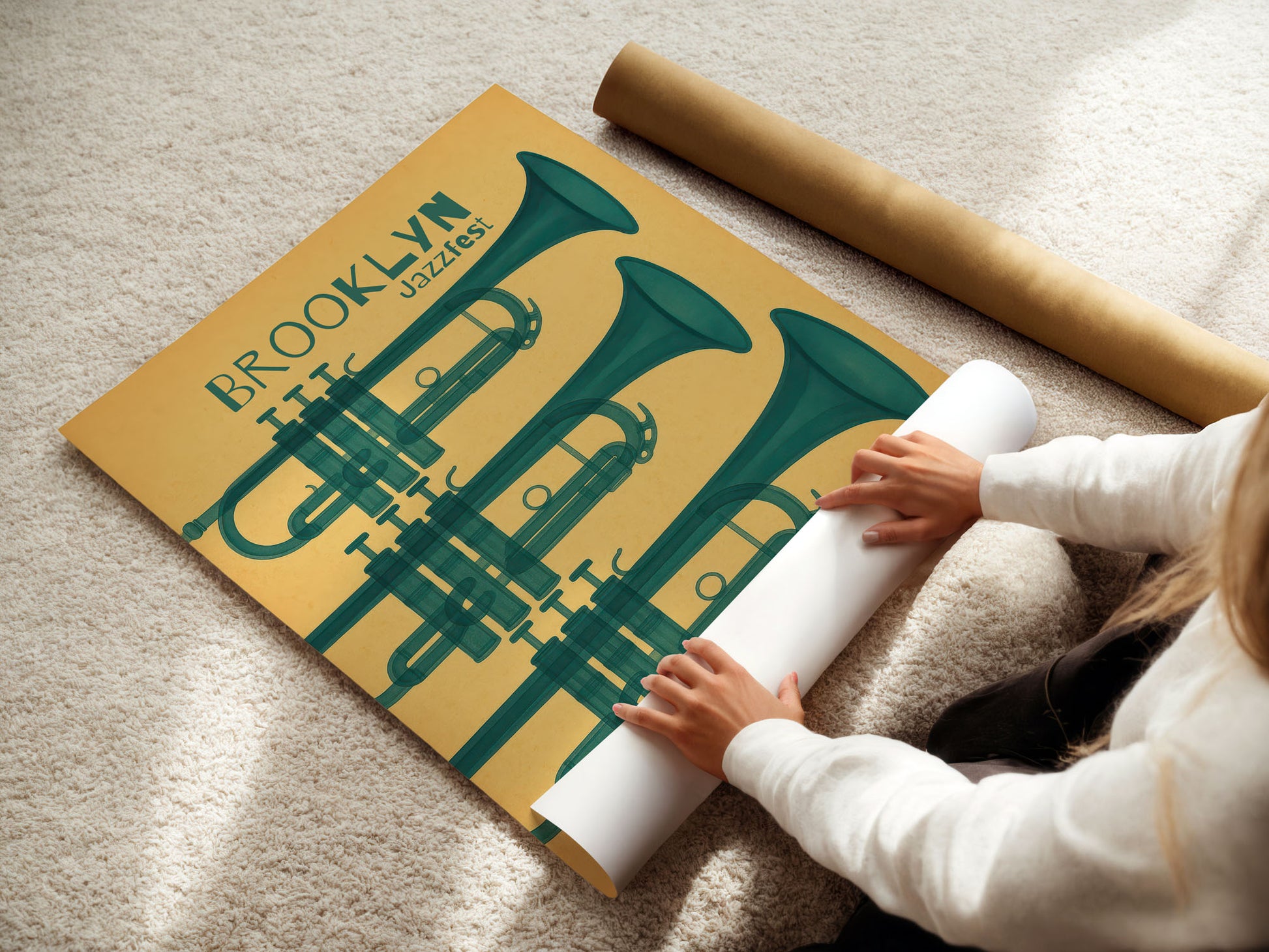 Person unrolling a poster with green trumpets and 'Brooklyn Jazz' text on a beige carpet.